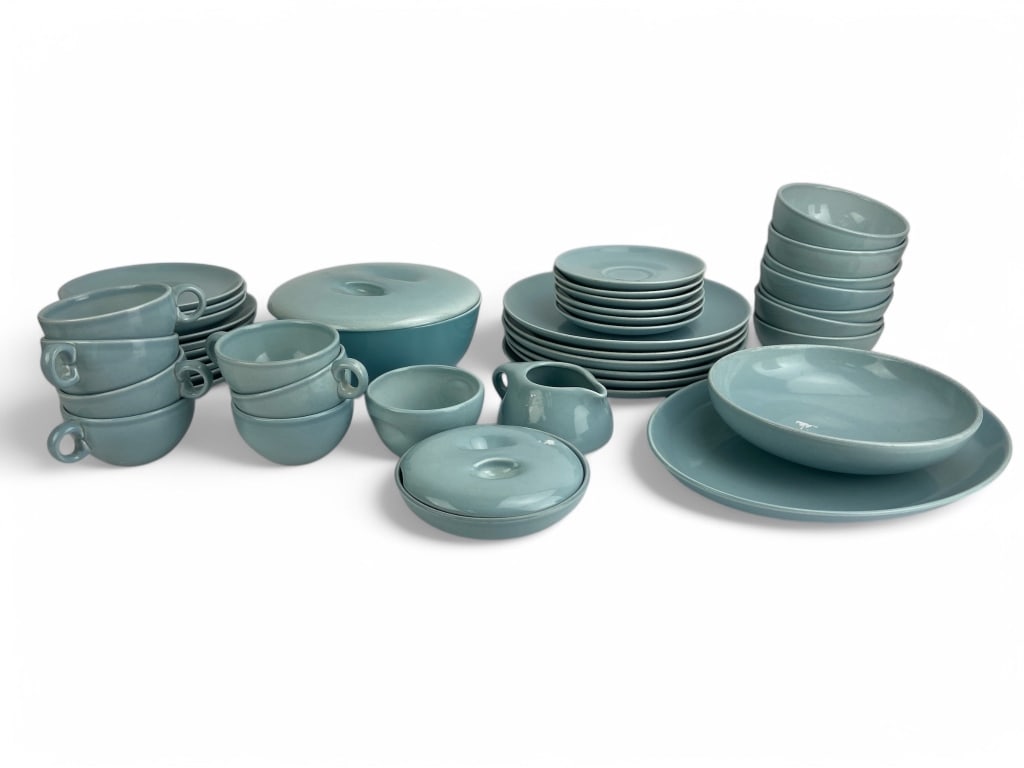 Russel Wright Iroquois Casual China Set: Dining set in blue glaze by Russel Wright for Iroquois Casual China. Includes various dinnerware, such as plates, bowls, cups with handles, and serving pieces.