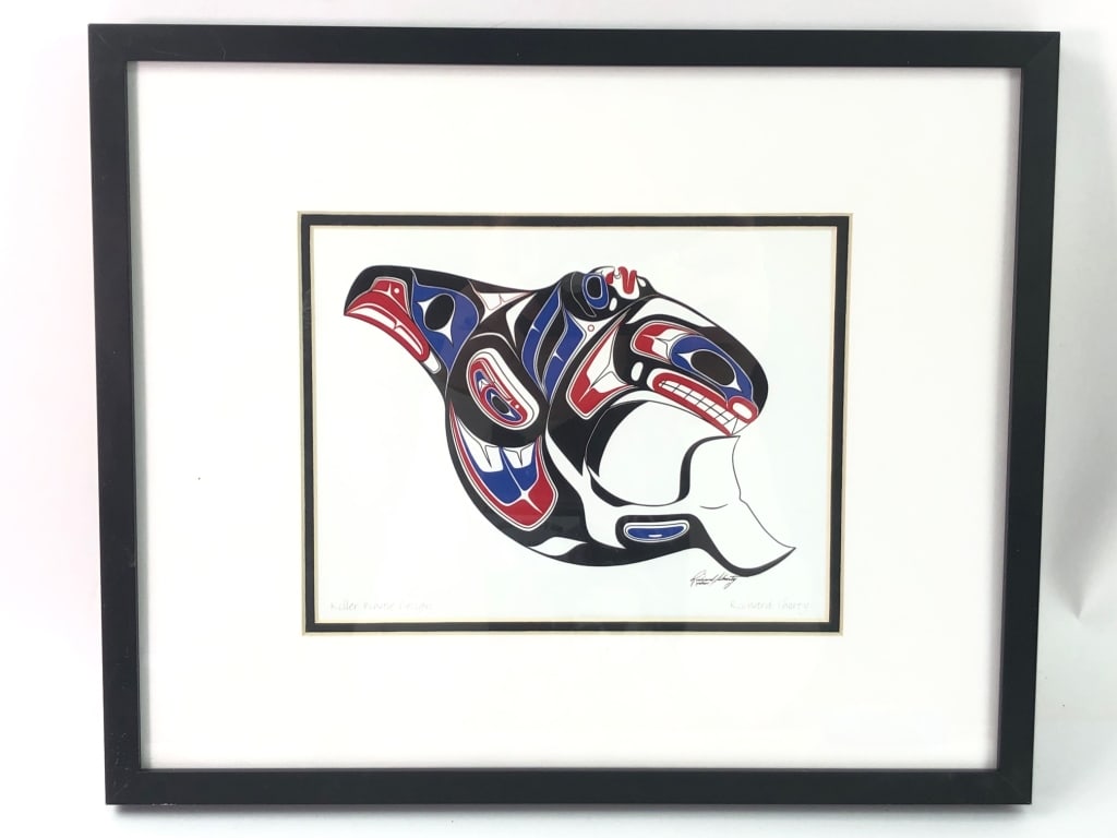 Killer Whale Design By Richard Shorty: Framed lithograph titled "Killer Whale Design" by artist Richard Shorty. The artwork measures 13.5" x 11" and features vibrant Indigenous-inspired motifs. Comes with attached information about the art