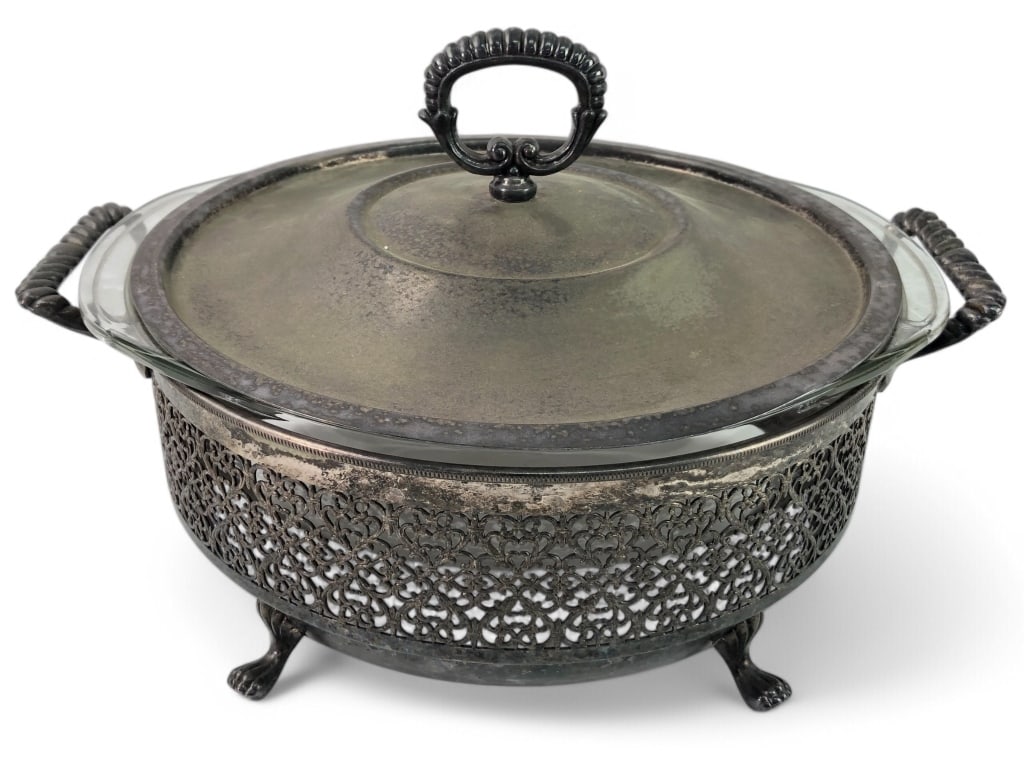 Pyrex Casserole In Ornate Metal Holder: Pyrex casserole dish with an 8 5/8" diameter (excluding handles) in an ornate metal holder featuring two handles and four feet. Includes a metal lid with a decorative top handle.