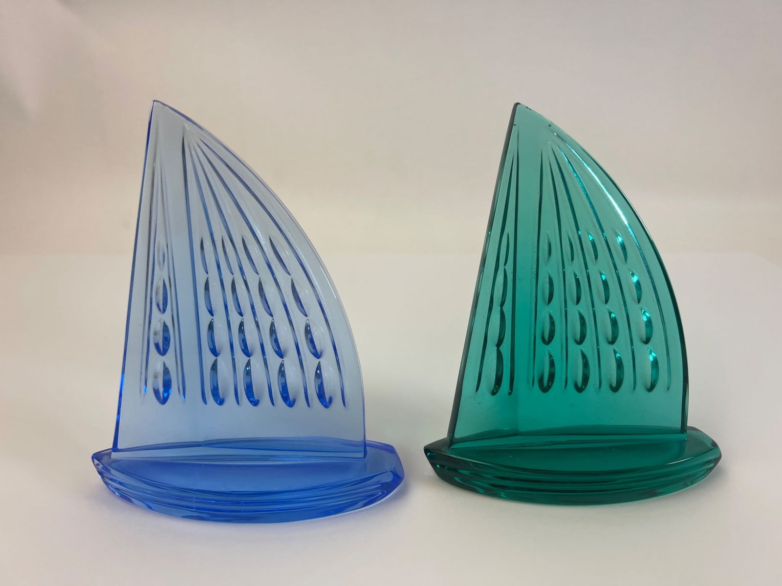 Waterford Crystal Sailboats: Waterford Crystal sailboat figurines in blue and green. Approximate height is 5.5 inches. Unsigned. Items feature elegant patterns on sails and stand upright on a flat base.