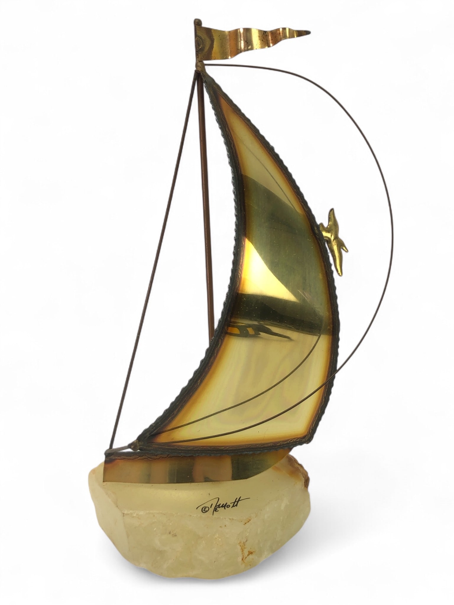 Signed John Demott Brass Sailboat Sculpture: Signed John DeMott sailboat sculpture made from brass and mounted on an onyx stone base. Measuring approximately 9 1/4 inches in height. Features a detailed sail and bird accent.