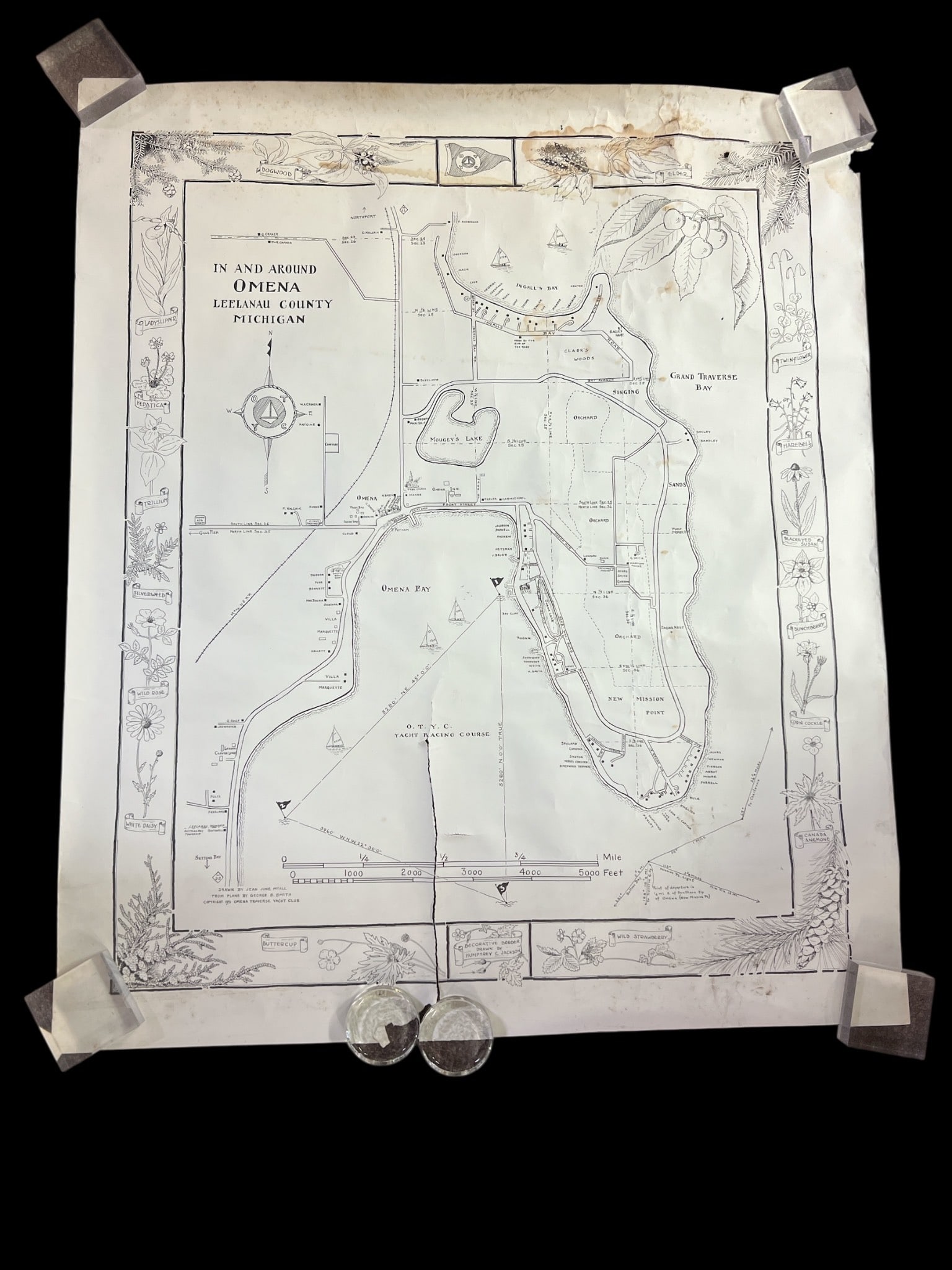 1951 Map Of Omena, Leelanau County: A 1951 map titled "In And Around Omena, Leelanau County, Michigan" drawn by Jean June Myall. Measures 32 x 38". Includes decorative border by Humphrey C. Jackson. Visible central tear and staining.