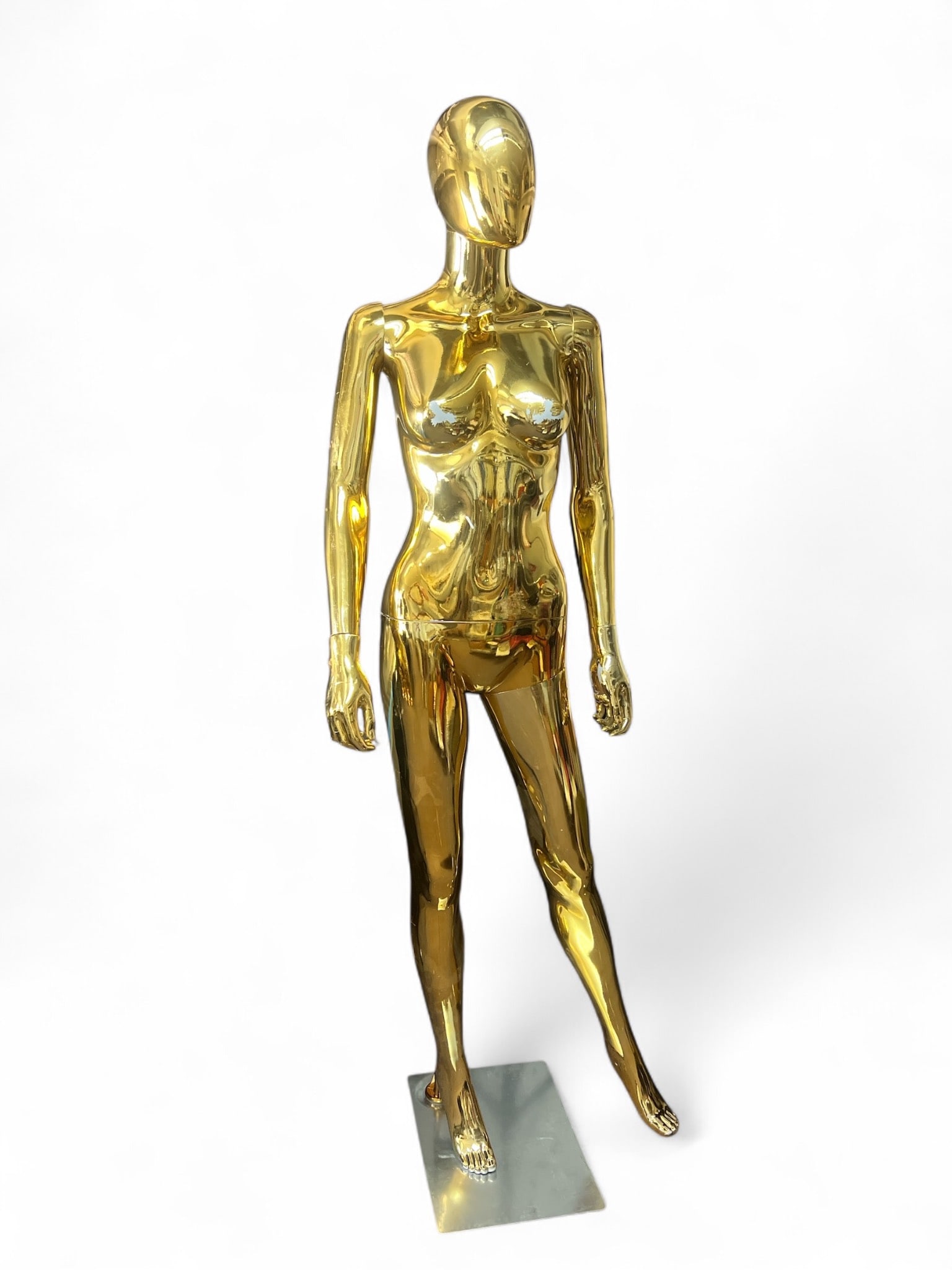 70"Gold Female Mannequin On Metal Base: A 70-inch tall gold female mannequin mounted on a metal base. The mannequin features a metallic gold finish with visible wear & scratches. Ideal as a display piece. L15