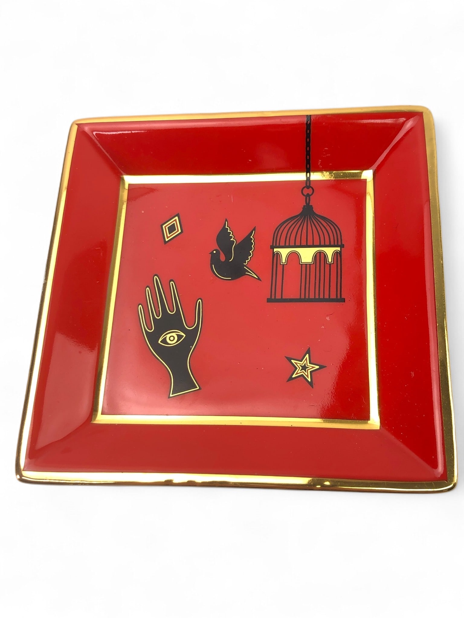 Jonathan Adler Bijoux Square Porcelain Tray: Jonathan Adler Bijoux square tray measuring 4.5" x 4.5". Made of porcelain, featuring a red design with gold accents and illustration details. Handmade in China. Noted wear present.