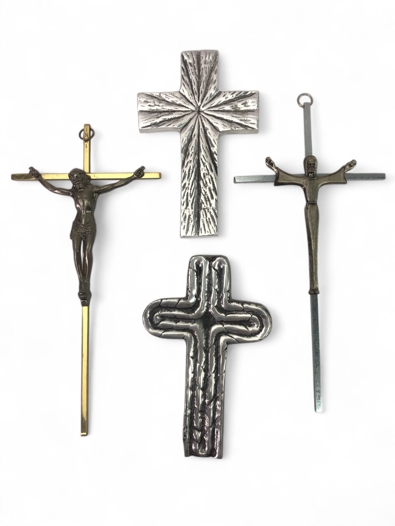 4 Metal Crosses With Various Designs: 4 metal crosses, including two crucifixes featuring Jesus Christ and two plain crosses with textured designs. Materials vary between silver and brass tones. One cross marked "Cancun Mexico."
