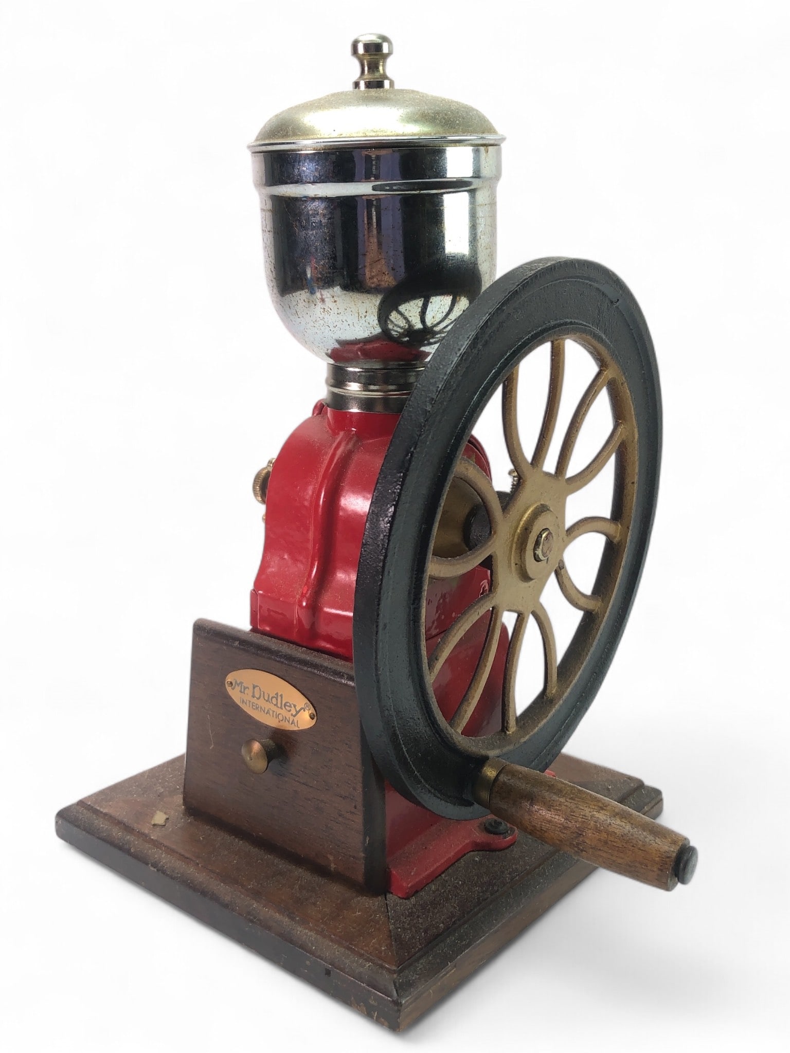 Mr. Dudley International Coffee Grinder: Mr. Dudley International coffee grinder, 11.5 inches tall, featuring a red cast metal and wood body with a hand-crank wheel and a metal hopper. Includes original instructions.