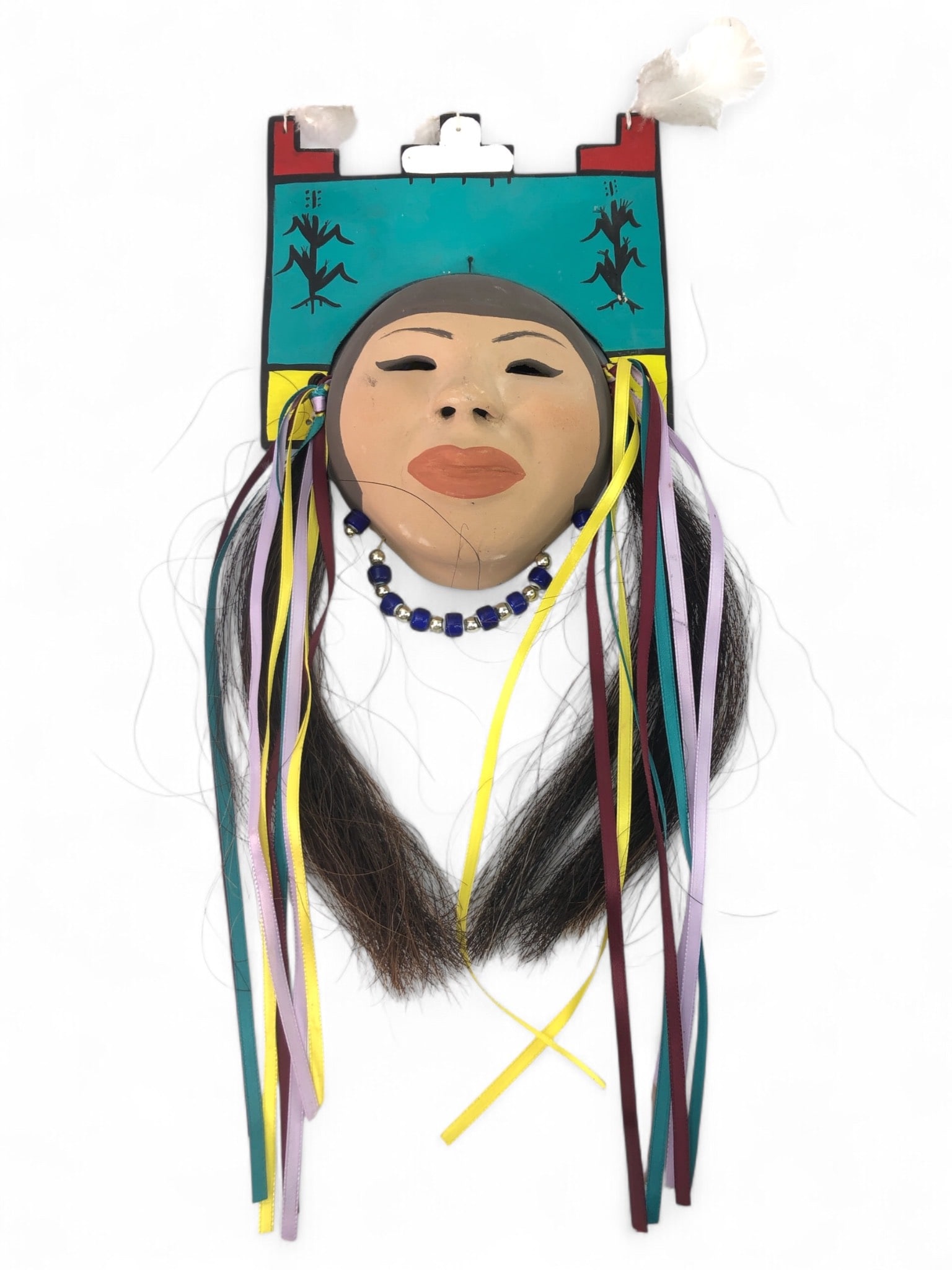 Fannie Loretto Jemez Pottery Mask 19"Long: Signed pottery mask by Fannie Loretto from Jemez Pueblo. Measures 19" long. Features painted design, natural hair accents, decorative ribbons, beadwork, and feathers. Shows visible wear to nose area.