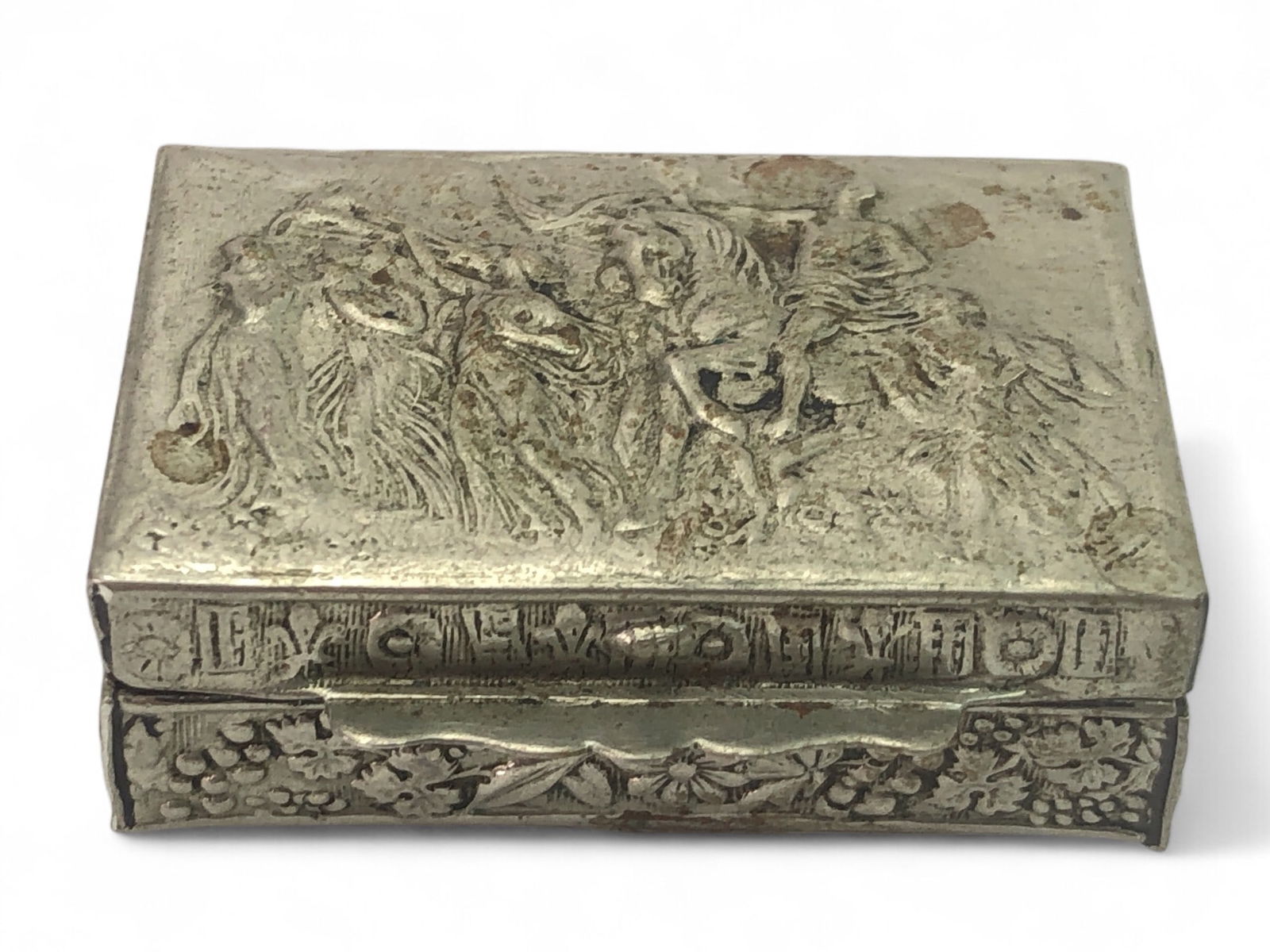 Made In Italy Metal Pill Box: Small rectangular metal pill box marked 'Made in Italy,' measuring 1.5" x 1" x 0.5". Features embossed designs depicting figures and floral motifs. Metal shows some wear.