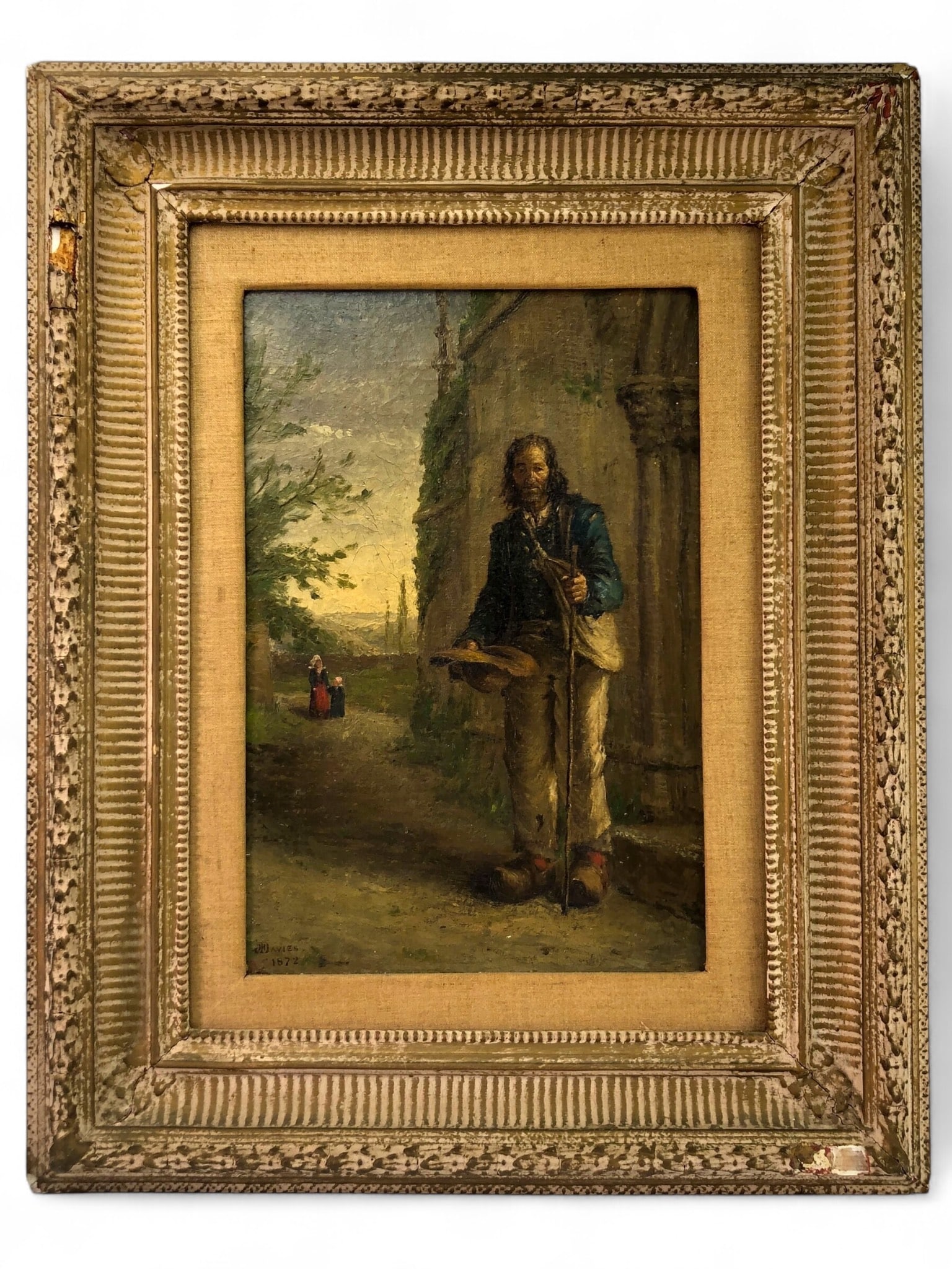19th Century “The Beggar?? Oil on Canvas Davies: Oil on canvas painting titled ‘The Beggar’ labeled J. F. Davies, dated 1872. Frame dimensions are 20.5 x 25.75 inches and housed in a period frame showing wear and cracks. The artwork depicts a be