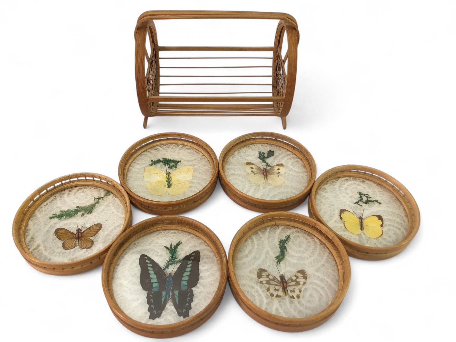 Vtg Pressed Butterfly Bamboo Coasters With Caddy: Six taxidermy butterfly coasters with a bamboo caddy. Coasters have a 4-inch diameter, featuring preserved butterflies with foliage beneath clear tops. Bamboo caddy included for storage.