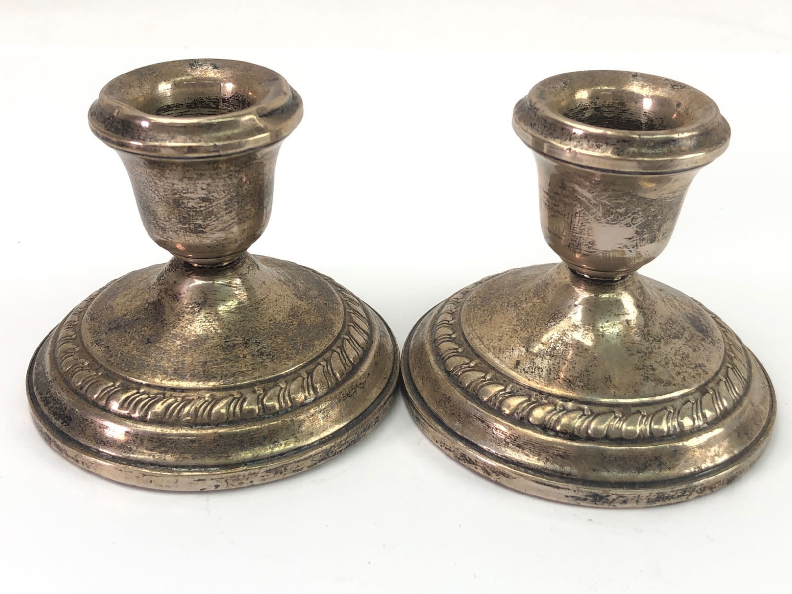 Sterling Columbia Weighted Candle Holders: Sterling silver weighted candle holders marked 'Sterling Columbia Weighted.' Each holder measures 2.5 inches tall, featuring a decorative border. The base shows signs of wear, consistent with age and