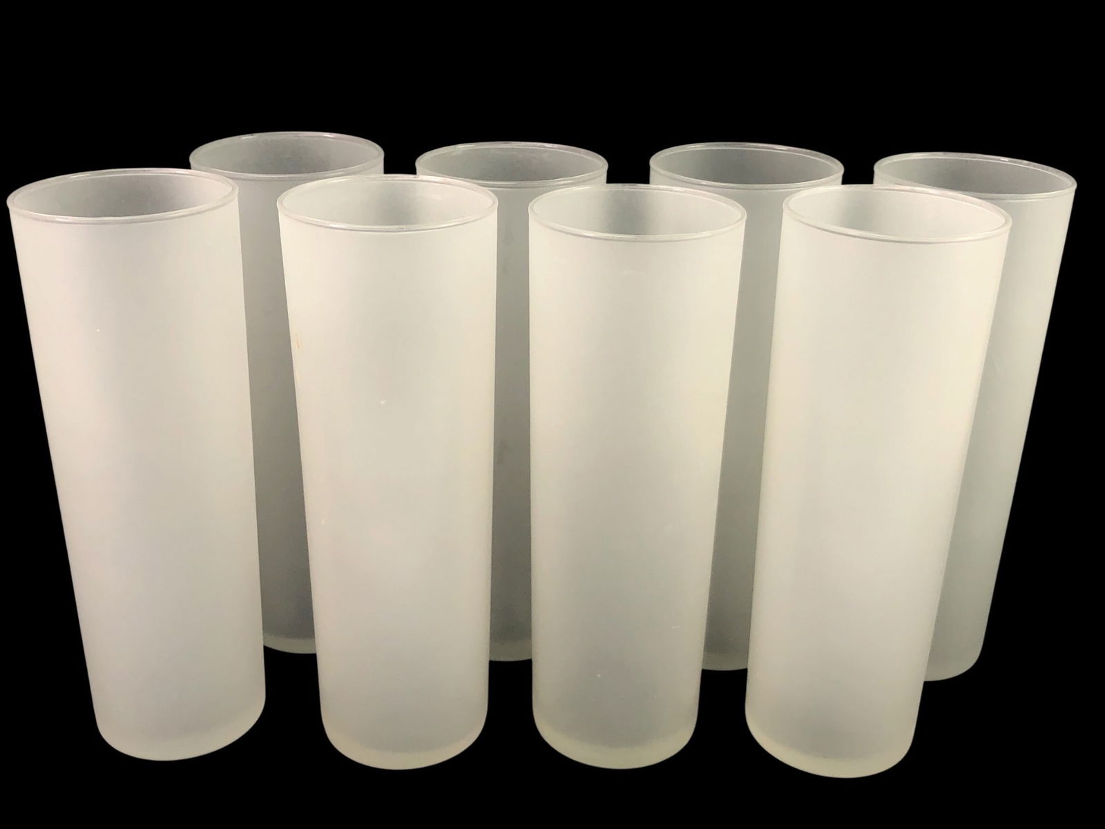 (8) Libbey Frosted Highball Glasses: Eight mid-century modern (MCM) Libbey frosted highball glasses, each measuring approximately 7 inches tall. Some wear includes small chips on the base and minor marks on the glass. Ideal for collector