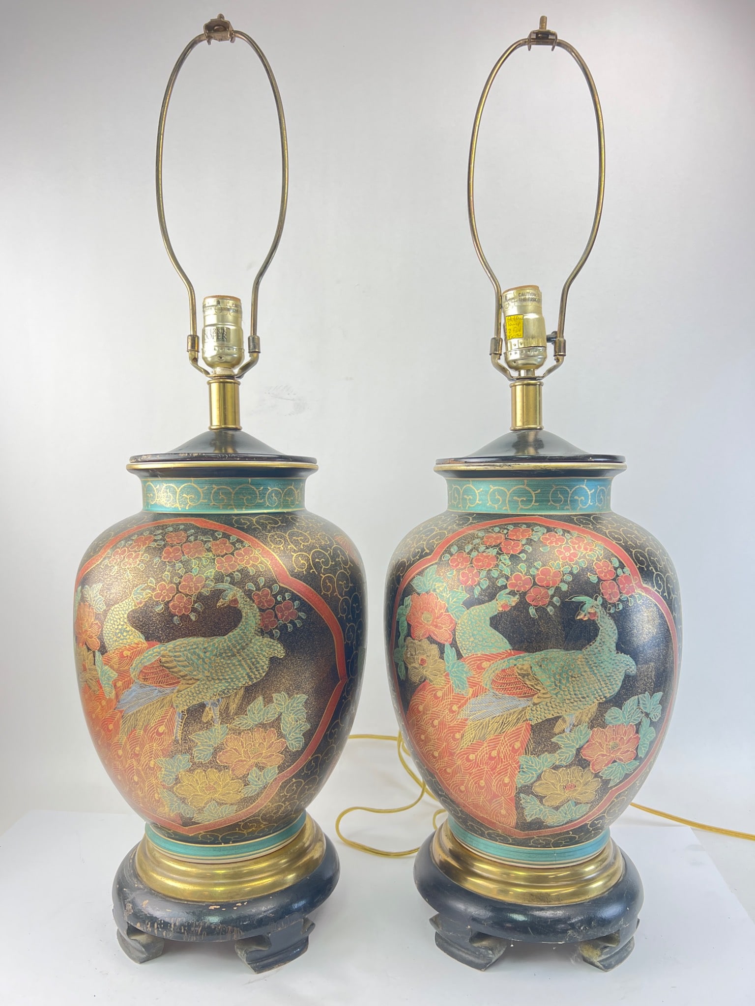 Frederick Cooper Table Lamps With Peacock Design: Frederick Cooper table lamps featuring a detailed peacock and floral design. Both lamps stand about 31 inches tall with some chipped paint on the wood bases. Includes original plugs and socket fitting