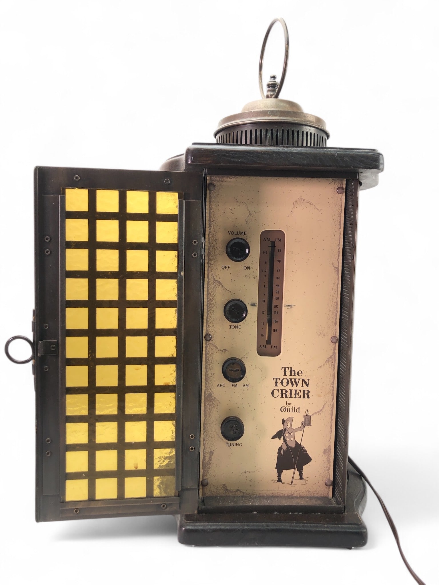 The Town Crier Guild Lantern Radio: The Town Crier by Guild FM radio housed in a lantern-style design with a 21-inch total height. Features ON/OFF, TONE, AFC, FM/AM, and TUNING controls. Tested and working on FM. Yellow grid-paneled doo