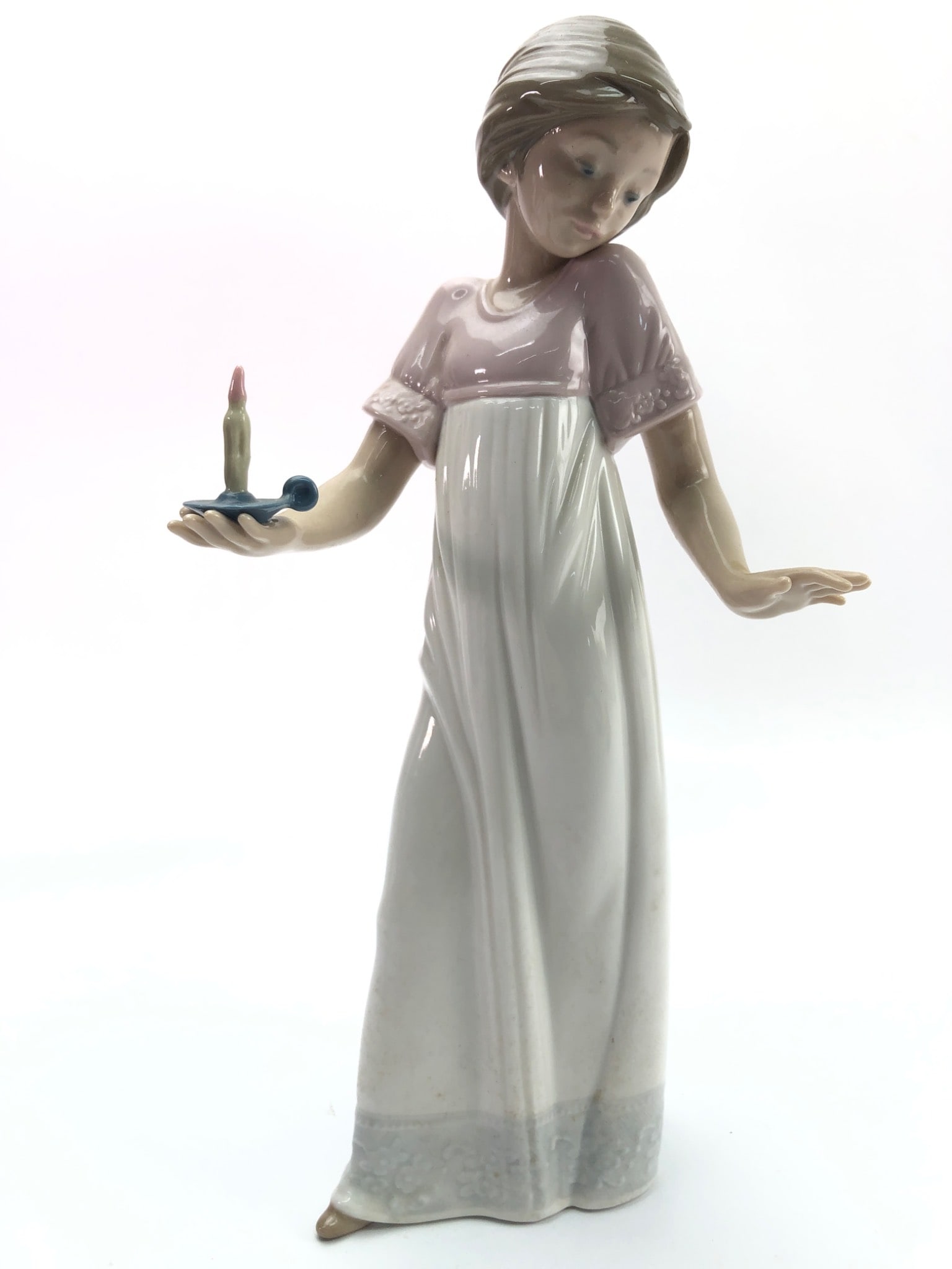 Nao By Lladro Girl With Candle Figurine: Porcelain figurine by Nao, a brand by Lladro, featuring a girl holding a candle on a tray, standing approximately 10 inches tall. Finished with delicate pastel tones and marked “Nao” on the ba