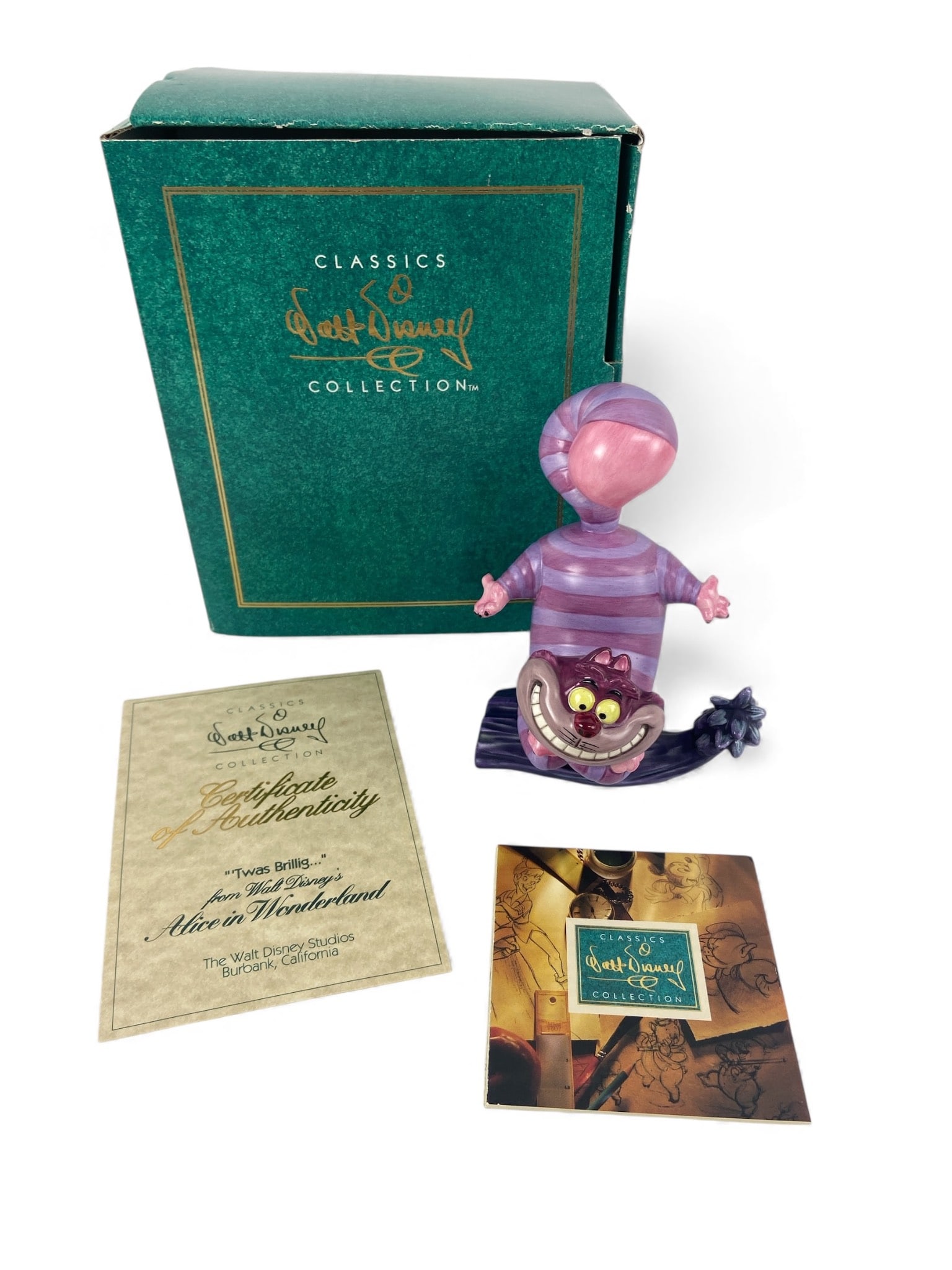 Walt Disney Cheshire Cat Sculpture ‘Twas Brillig’: A figurine from the Walt Disney Classics Collection featuring the Cheshire Cat from Alice in Wonderland. Includes the original box, certificate of authenticity, & pamphlet. Sculpture dimensions are 4.