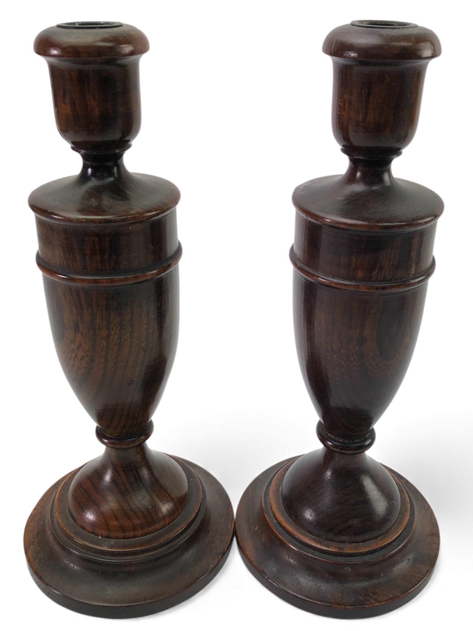 Antique Turned Wood Baluster Candlesticks: Antique turned wood baluster candlesticks measuring 10.5 inches tall. Crafted from dark wood with visible grain patterns and featuring a round base. The bases exhibit wear, consistent with age. The to