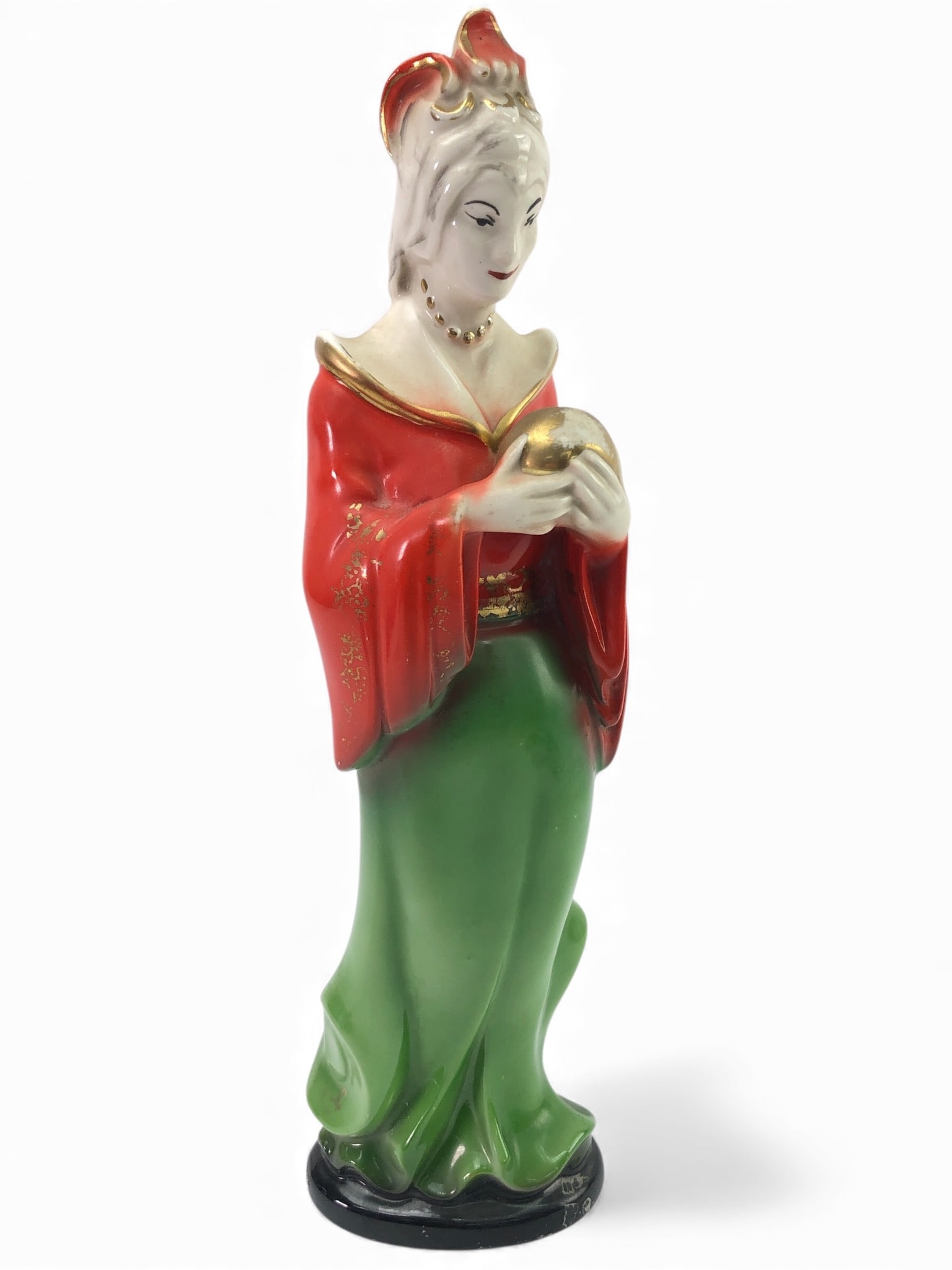 13 Tall Porcelain Geisha Figurine: 13-inch tall porcelain figurine of a geisha dressed in a red & green outfit with gold accents. Features intricate facial details & holding a gold orb. Base shows wear, including visible chips & adhesi