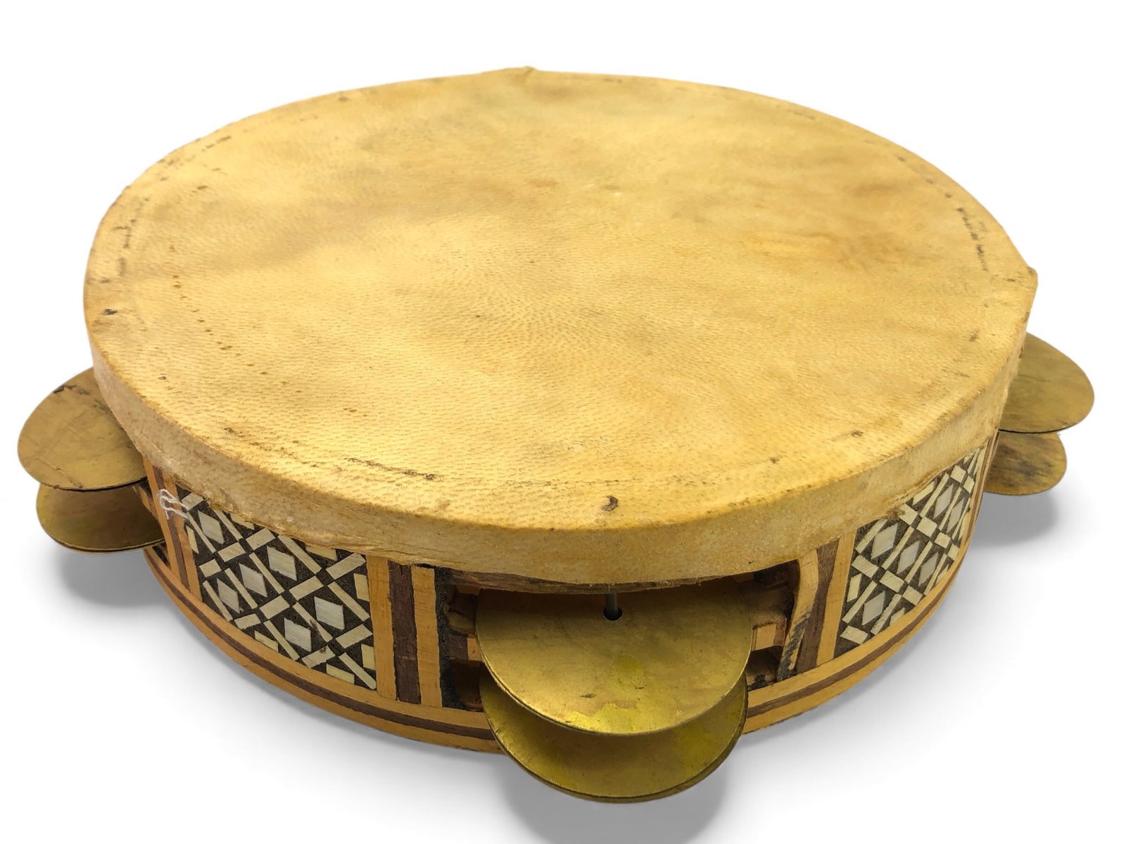 Classic Arabic Riq Frame Drum With Geometric Inlay: Classic Arabic Riq frame drum featuring an 8.5-inch diameter head made from natural skin. Decorated with geometric inlay along the wooden frame, it includes multiple brass jingles for added sound text
