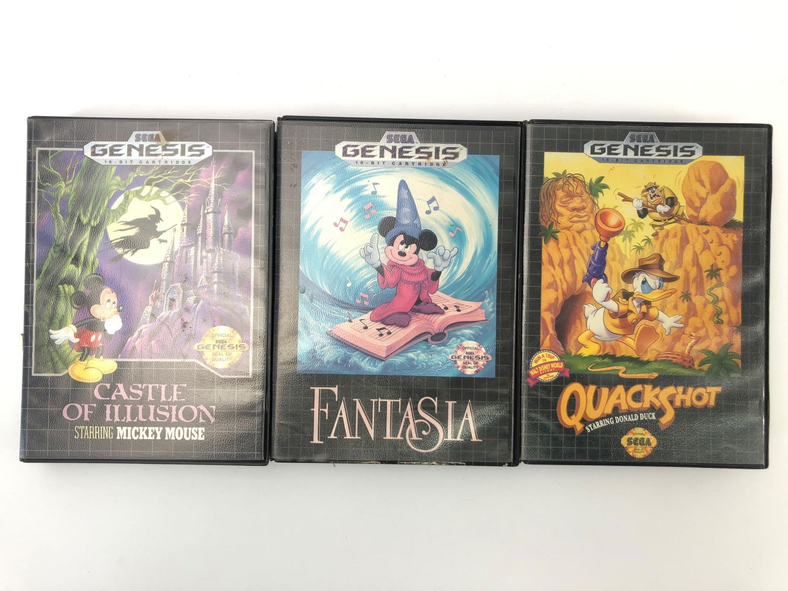 Sega Genesis Mickey & Donald Games Lot: Three Sega Genesis video games including Castle Of Illusion Starring Mickey Mouse, Fantasia, & QuackShot Starring Donald Duck. Includes original game cases & cartridges. Visible wear on some cartridge