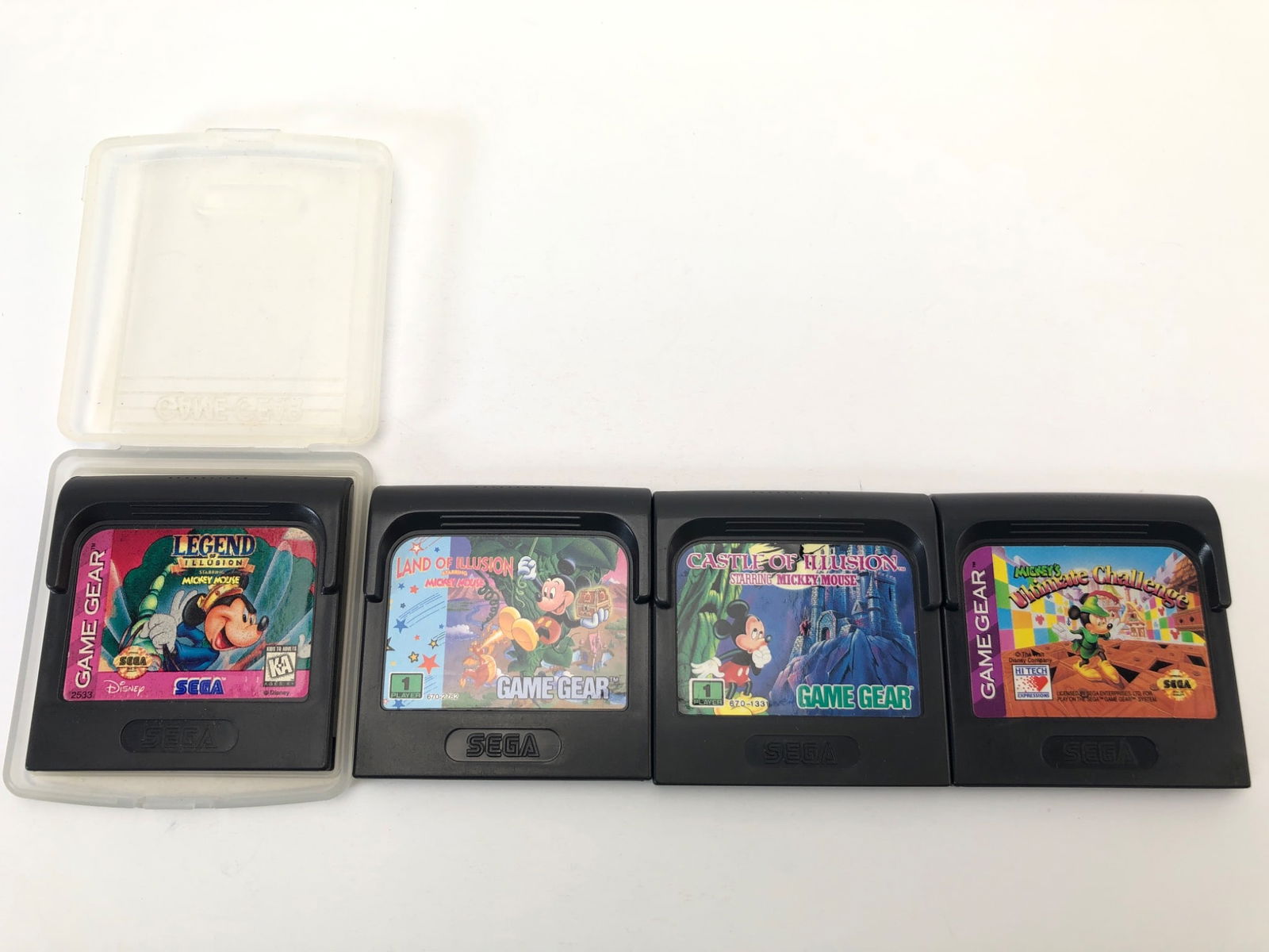 4 Mickey Mouse Sega Game Gear Games: 4 Sega Game Gear cartridges featuring Mickey Mouse titles: Castle of Illusion, Land of Illusion, Legend of Illusion, & Mickey's Ultimate Challenge. Includes one plastic case. Games show signs of use.
