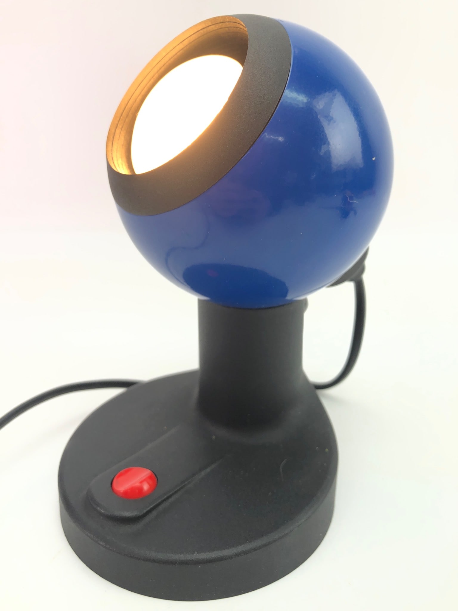 Vtg Artemide Eclisse-Style Space Age Lamp: Vintage Artemide Eclisse-style space age "eyeball" portable lamp with an adjustable shade. Measures 7 inches tall. Features a blue spherical shade, black base with a red on/off button, and a two-prong