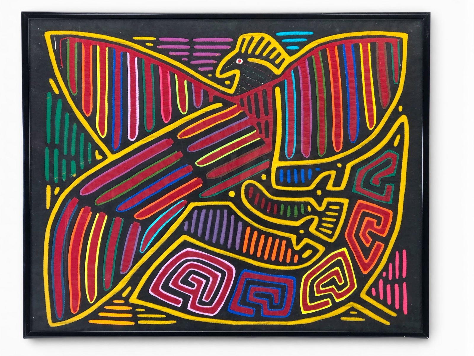 Vtg Kuna Mola Hand Sewn Textile Folk Art: Vtg Kuna Mola hand-sewn textile folk art featuring multicolored traditional designs and a bird motif. Dimensions are 17 3/4 x 14 1/4 inches. Displayed in a black frame with hanging hardware on the rev