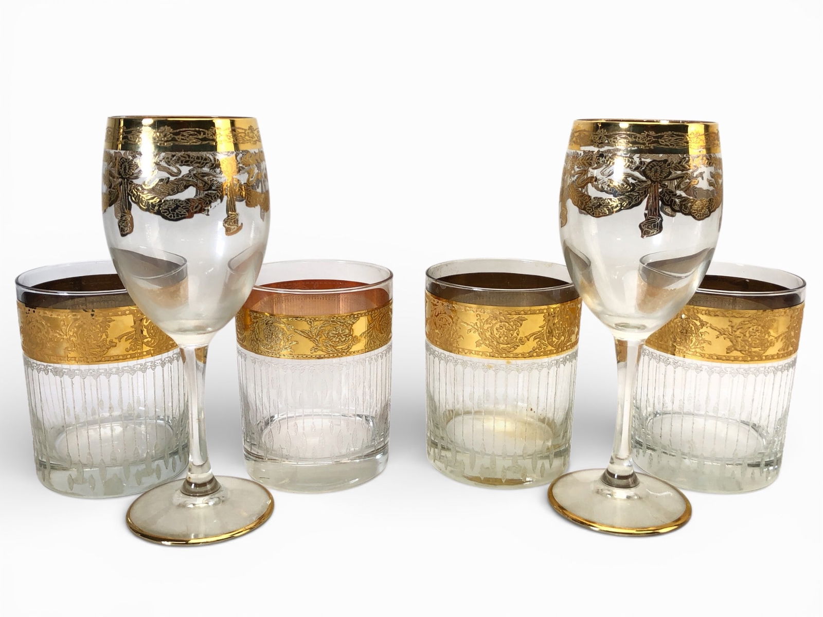 Vtg Culver Tyrol Glasses With 22K Gold Rims: Six Culver Tyrol glasses featuring 22K gold accents. Includes two wine glasses, each approximately 7.25 inches tall, and four rocks glasses, each approximately 4.25 inches tall. Design includes intric