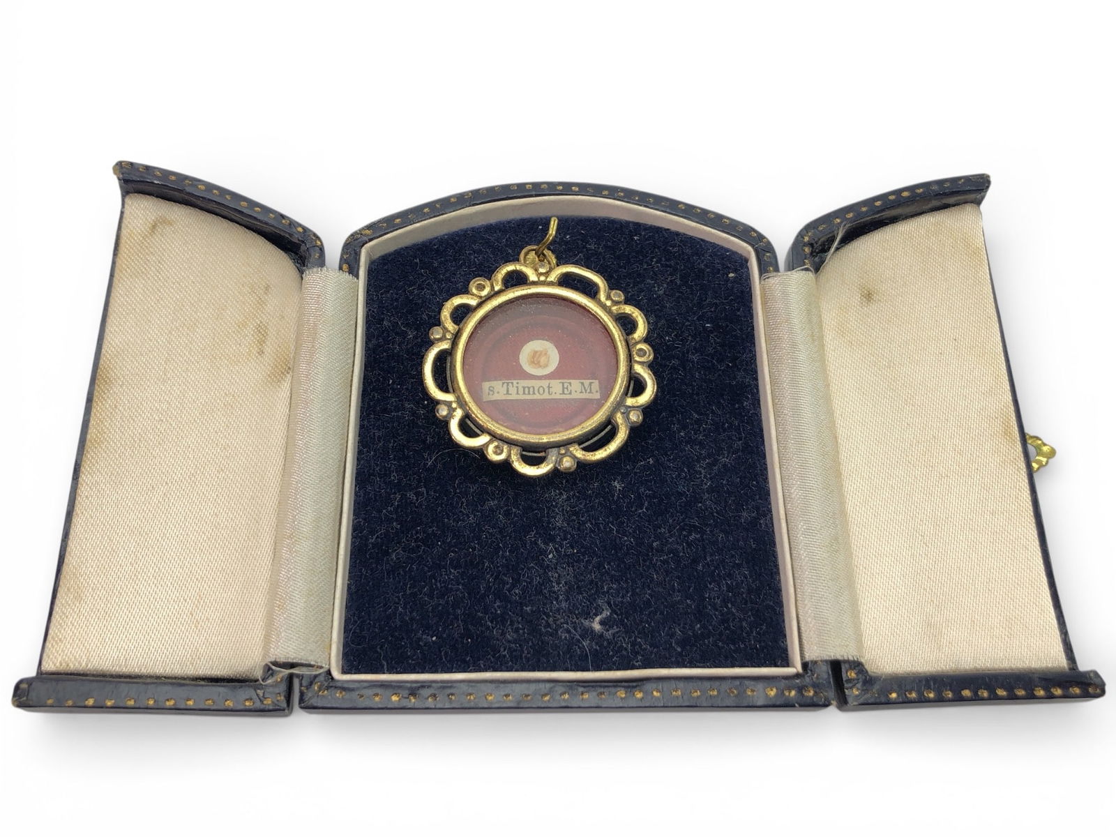 Metal Reliquary First-Class Relic Of St. Timothy: Metal reliquary featuring a first-class relic of St. Timothy, housed in a decorative gold-tone case measuring 3 inches long. Includes a fitted blue presentation case with a gold latch and wear