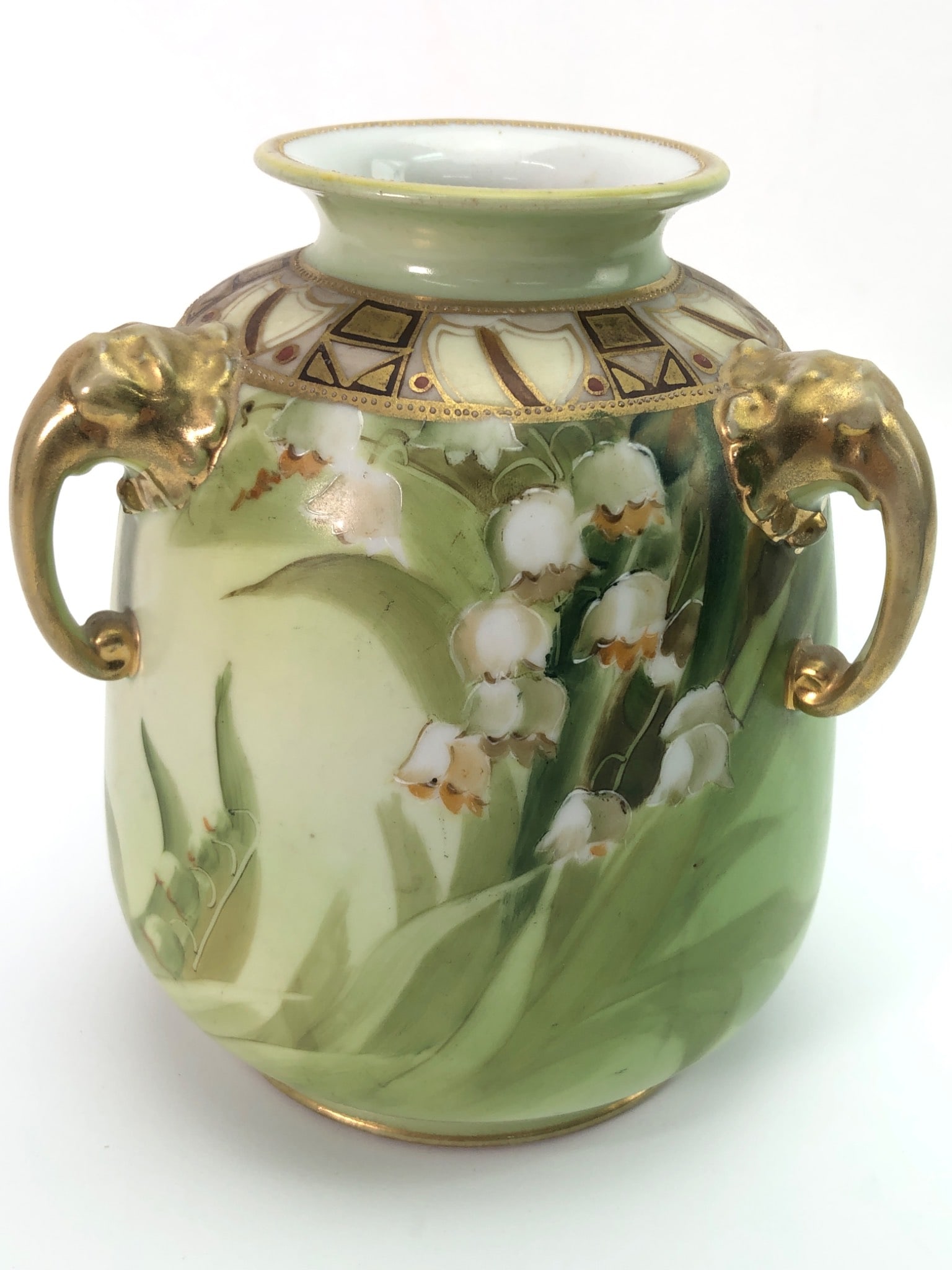 Hand Painted Nippon Vase With Elephant Handles: Hand-painted Nippon vase standing 6.25 inches tall. Features lily of the valley floral design, gold embellishments, and two elephant-shaped handles. Marked on the base with "Hand Painted Nippon" and M