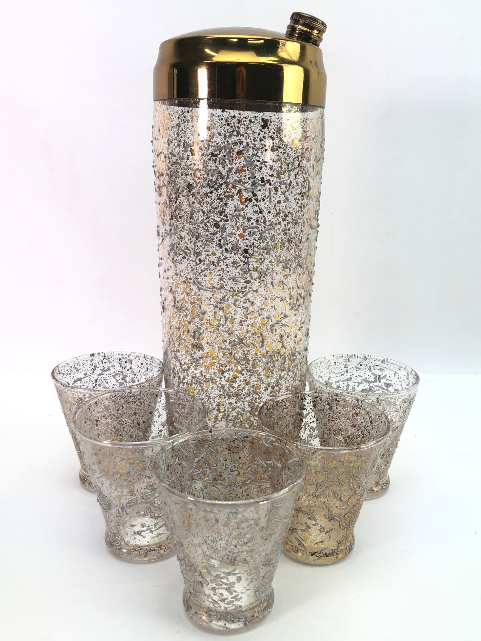 Rare MCM West Virginia Glass Gold & White Cocktail Set: Rare Mid-Century Modern (MCM) West Virginia Glass cocktail shaker set featuring gold & white embossed splatter designs. Includes one 11-inch tall shaker with a gold lid & five matching 3-inch tall gla