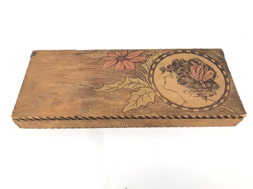 Pyrography Wooden Box W/ Floral & Woman Design: Wooden pyrography box measuring 12"x 5"x 1 1/2”. Features a floral design with holly & a poinsettia, alongside a profile of a woman with a butterfly in her hair. Hinged lid, with interior suitab