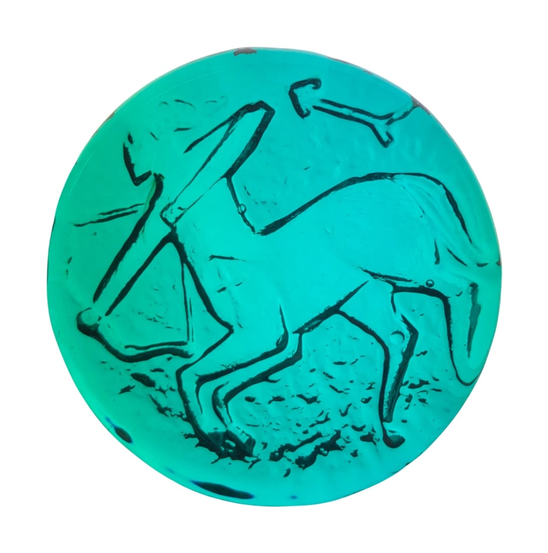 VTG Blenko Azure Blue Sagittarius Zodiac Paperweight: VTG Blenko art glass paperweight in azure blue. This hand-blown piece features a pressed Sagittarius zodiac motif. Unmarked. 4" dia. Shows minor surface wear and light scratches consistent with age.