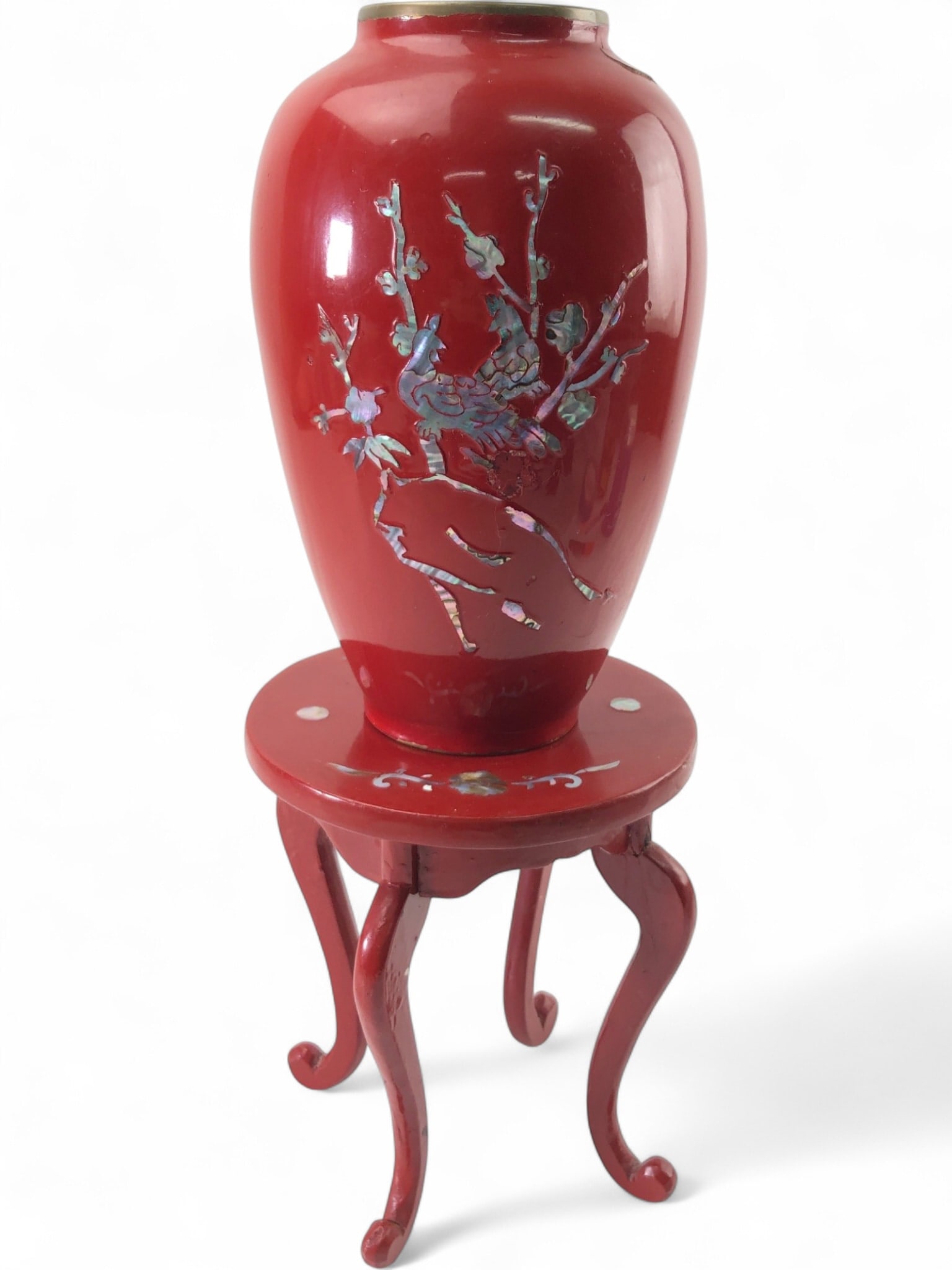VTG Korean Enamel Brass MOP Inlay Vase & Stand: Vintage Korean red enamel over brass cloisonné vase with mother-of-pearl inlay, depicting a bird on a branch. The vase measures 8" tall. Accompanied by a matching red wood stand with cabriole legs an