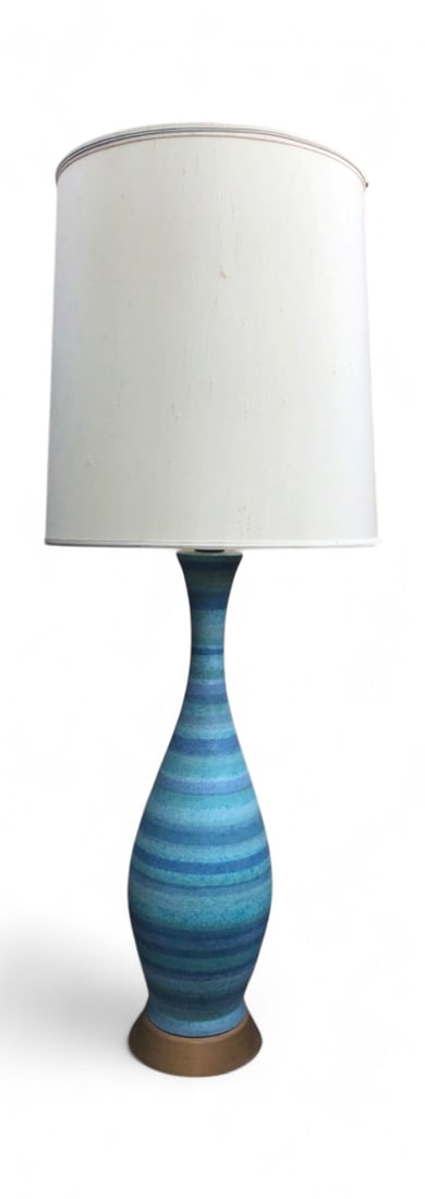 MCM Blue Striped Ceramic Table Lamp: Mid-Century Modern ceramic table lamp featuring a tapered body with horizontal stripes in varying shades of blue and turquoise. Mounted on a circular wood base. Includes a Stiffel branded silk-style d