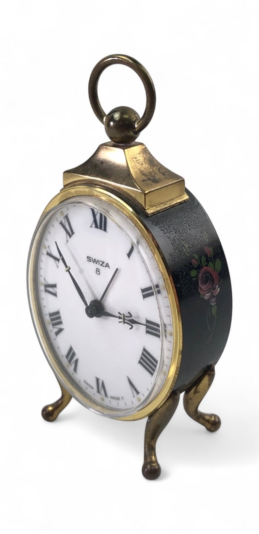 VTG Swiza 8 Day Hand Painted Mechanical Alarm Clock: Vintage Swiza 8 day mechanical alarm clock featuring a brass case with an oval white dial and Roman numeral markers. The black enameled sides are decorated with hand-painted floral rose motifs.