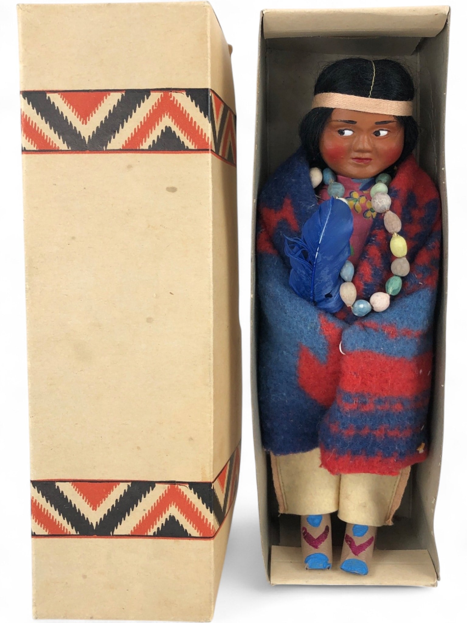 SKOOKUM Indian Character Doll in Original Box: Vintage SKOOKUM 'The Great Indian Character Doll' in original box, c. 1942. Features composition head with painted facial features, black hair, wrapped in a red & blue striped wool blanket, wearing