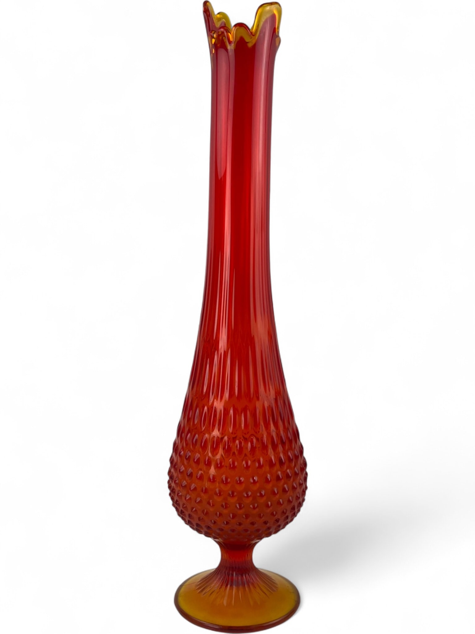 Fenton Amberina Hobnail Swung Glass Vase, 20": A tall Amberina art glass swung vase by Fenton. Features a bulbous base with a hobnail pattern transitioning into a long ribbed neck with a ruffled, flame-like rim. The circular foot has a rayed