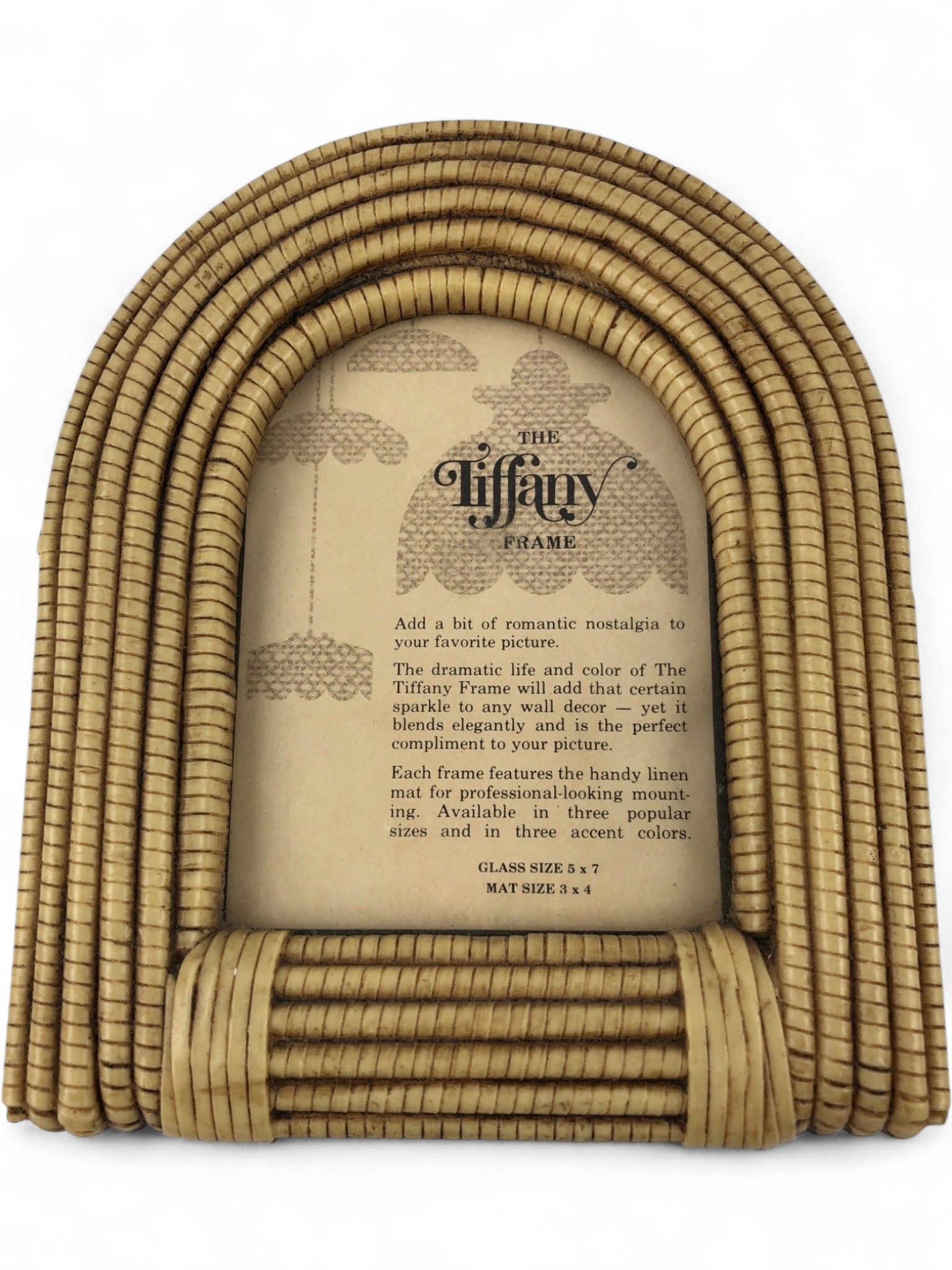 The Tiffany Frame Faux Rattan Picture Frame: A vintage-style arched picture frame by The Tiffany Frame, featuring a tiered faux rattan or reed design in a light tan color. The frame includes a black textured plastic backing with an integrated