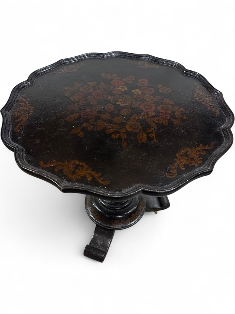 Maitland-Smith Hand Painted Pedestal Table: Hand painted and hand made pedestal table by Maitland-Smith. Features a scalloped top with floral motif and scroll-foot tripod base on brass casters. Black lacquered finish with gilt-style accents. Sh