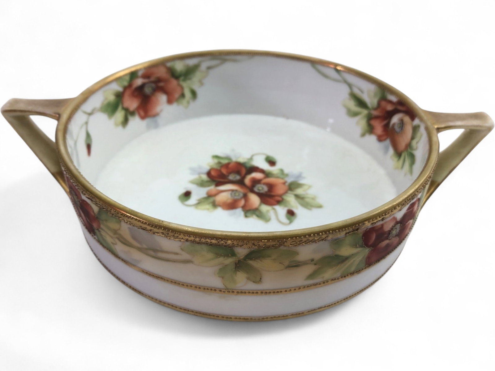 Nippon Hand-Painted Porcelain Poppy Nut Bowl: A hand-painted porcelain nut bowl or candy dish by Nippon. The piece features a vibrant red and orange poppy motif with green foliage, accented by raised gold moriage beading and gilded handles. The i