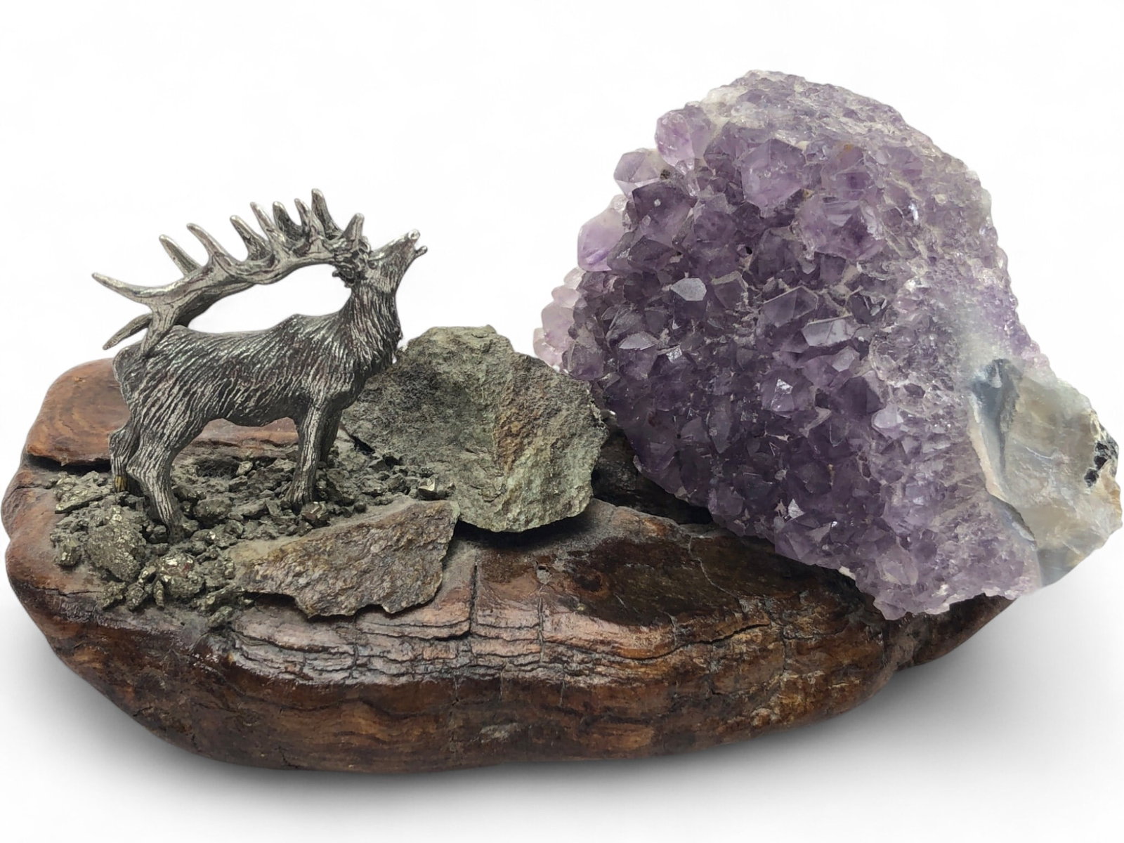 Pewter Elk and Amethyst Geode on Burl Wood Base: A decorative sculpture featuring a cast pewter elk in a bugling pose, set upon a natural burl wood base. The scene is accented with a large amethyst geode cluster, pyrite 'fool's gold' chips, and addi