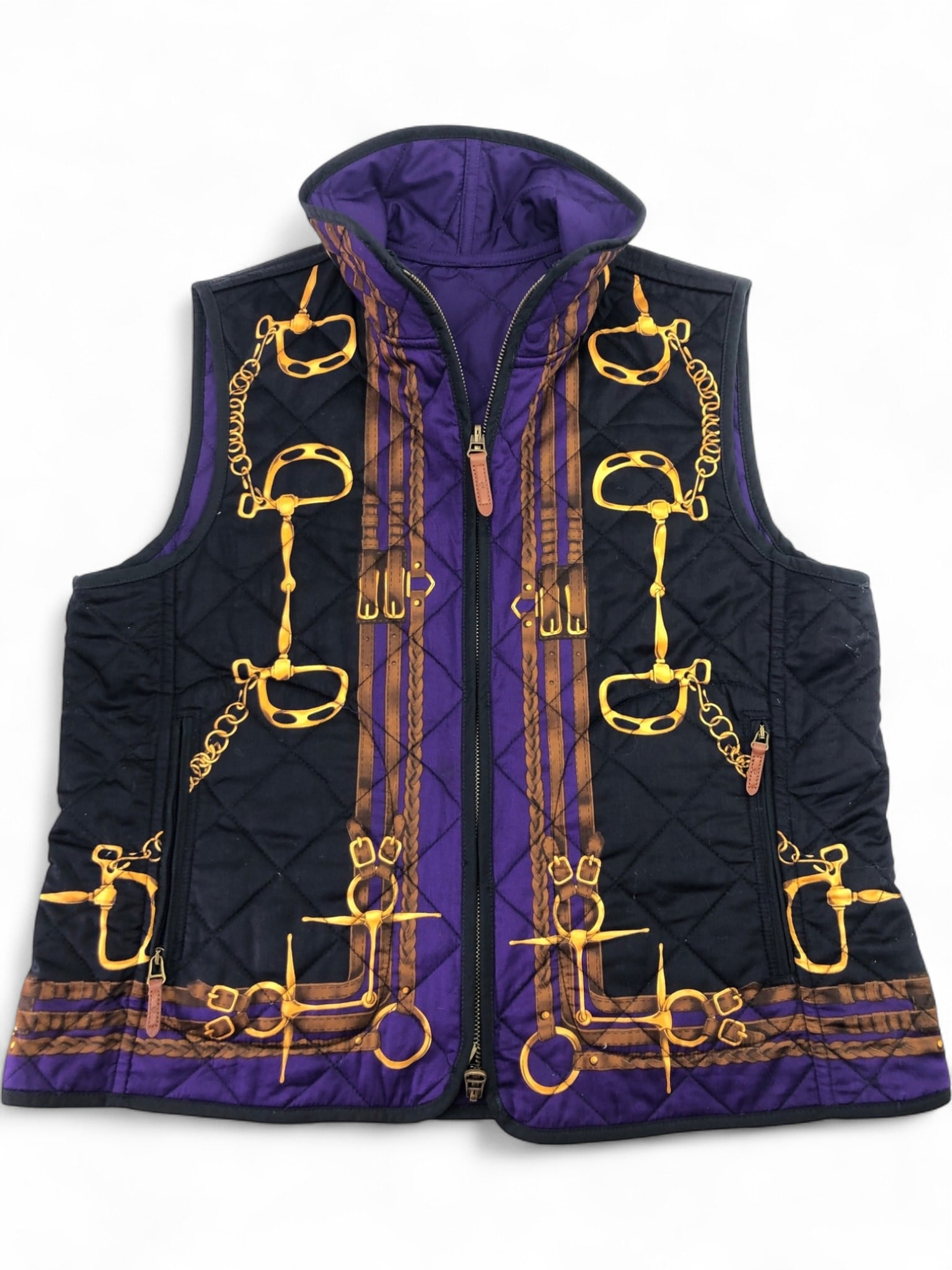 Ralph Lauren Reversible Quilted Equestrian Vest: A reversible quilted vest by Lauren Ralph Lauren featuring a vibrant equestrian print with bits and bridles on one side and a solid purple on the other. Constructed with a 100% cotton shell on the pat