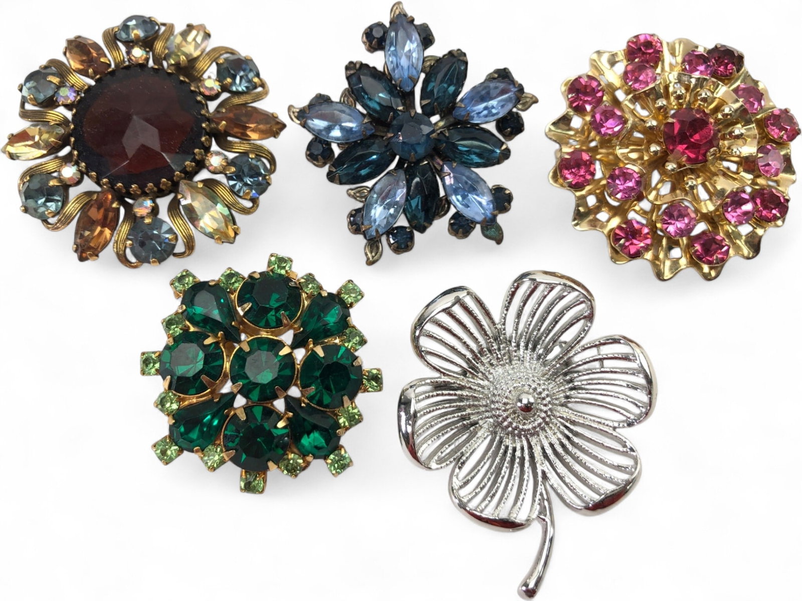 VTG Weiss and Assorted Costume Flower Brooches: Lot of 5 vintage flower-themed costume brooches. Includes a large Weiss signed brooch with a central amber-colored cabochon and multi-colored rhinestones, a blue marquise rhinestone floral spray, a pi