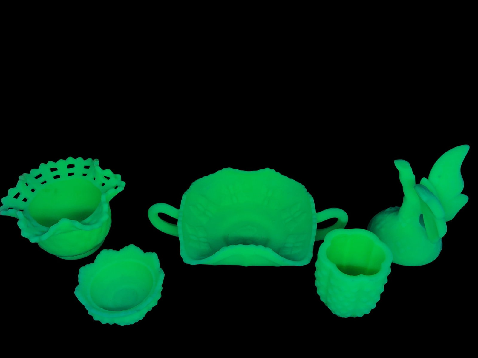 Fenton Green Satin Custard Uranium Glass Lot: A five-piece collection of Fenton Art Glass in green satin custard glass, featuring a strong green fluorescence under UV light (uranium glass). The lot includes a basket-weave open-lace bowl, a butter