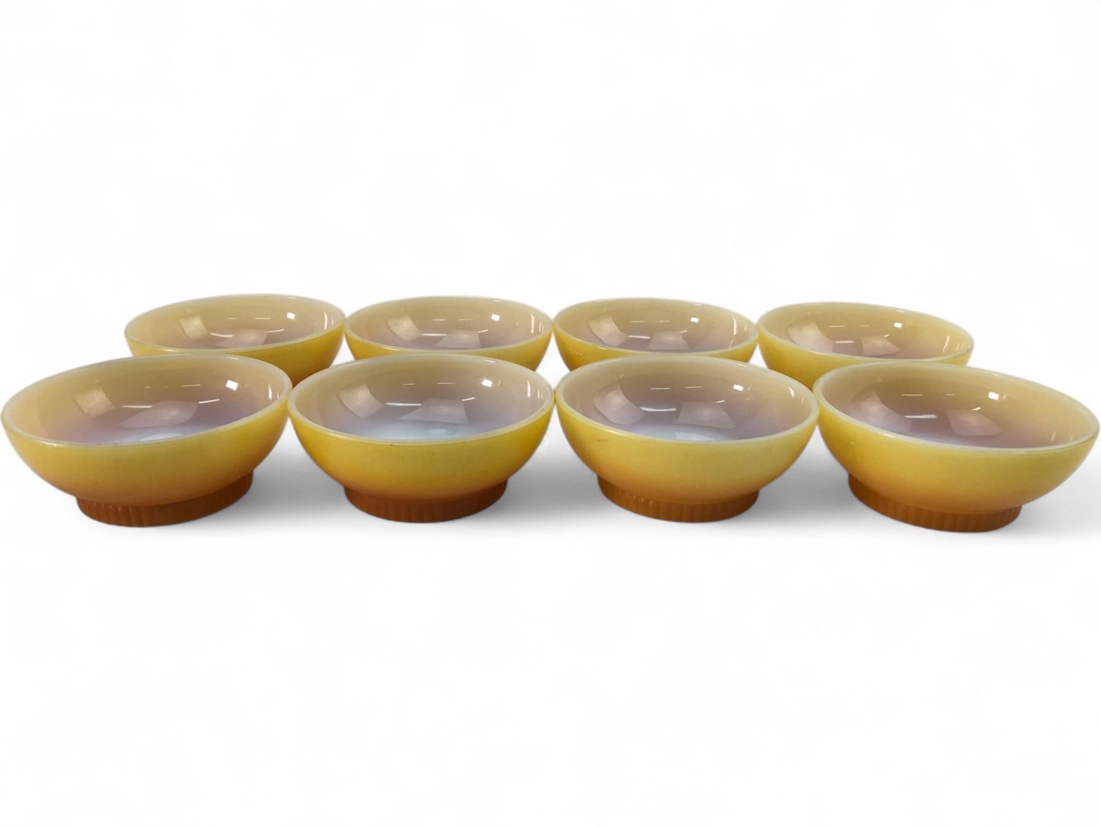 VTG Fire-King Yellow Ombre Milk Glass Bowls, Set of 8: Set of eight vintage Fire-King cereal or soup bowls featuring a yellow to butterscotch ombre finish on milk glass. Each bowl is designed with a ribbed pedestal base. Marked on the underside "Anchor Ho