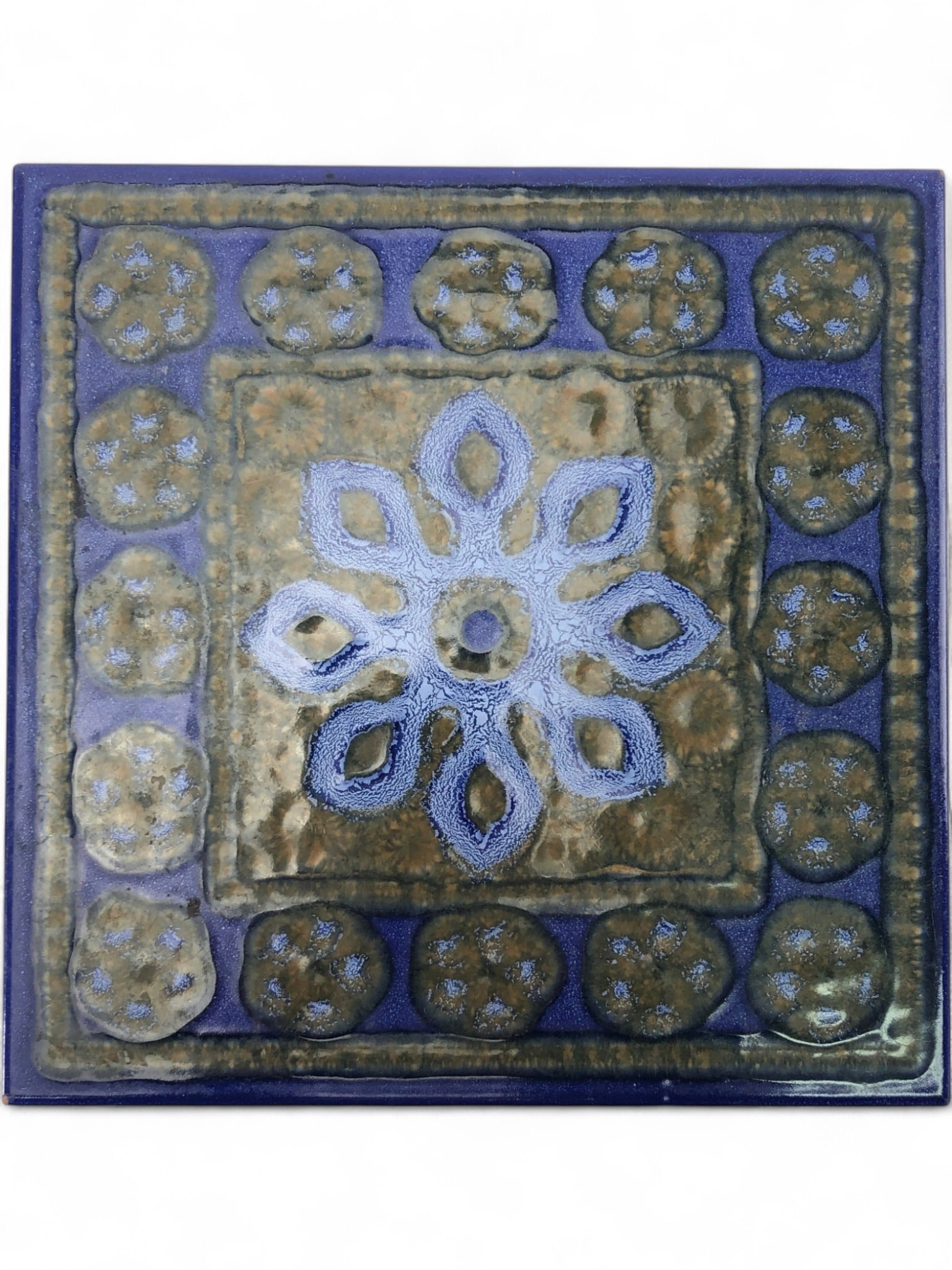 Piemme Mid-Century Modern Floral Ceramic Tile: Piemme Mid-Century Modern ceramic tile, 7 3/4 x 7 3/4. Features a stylized blue floral design on a mottled brown/tan ground, with a deep blue border and raised circular elements. Made in Italy. Impres