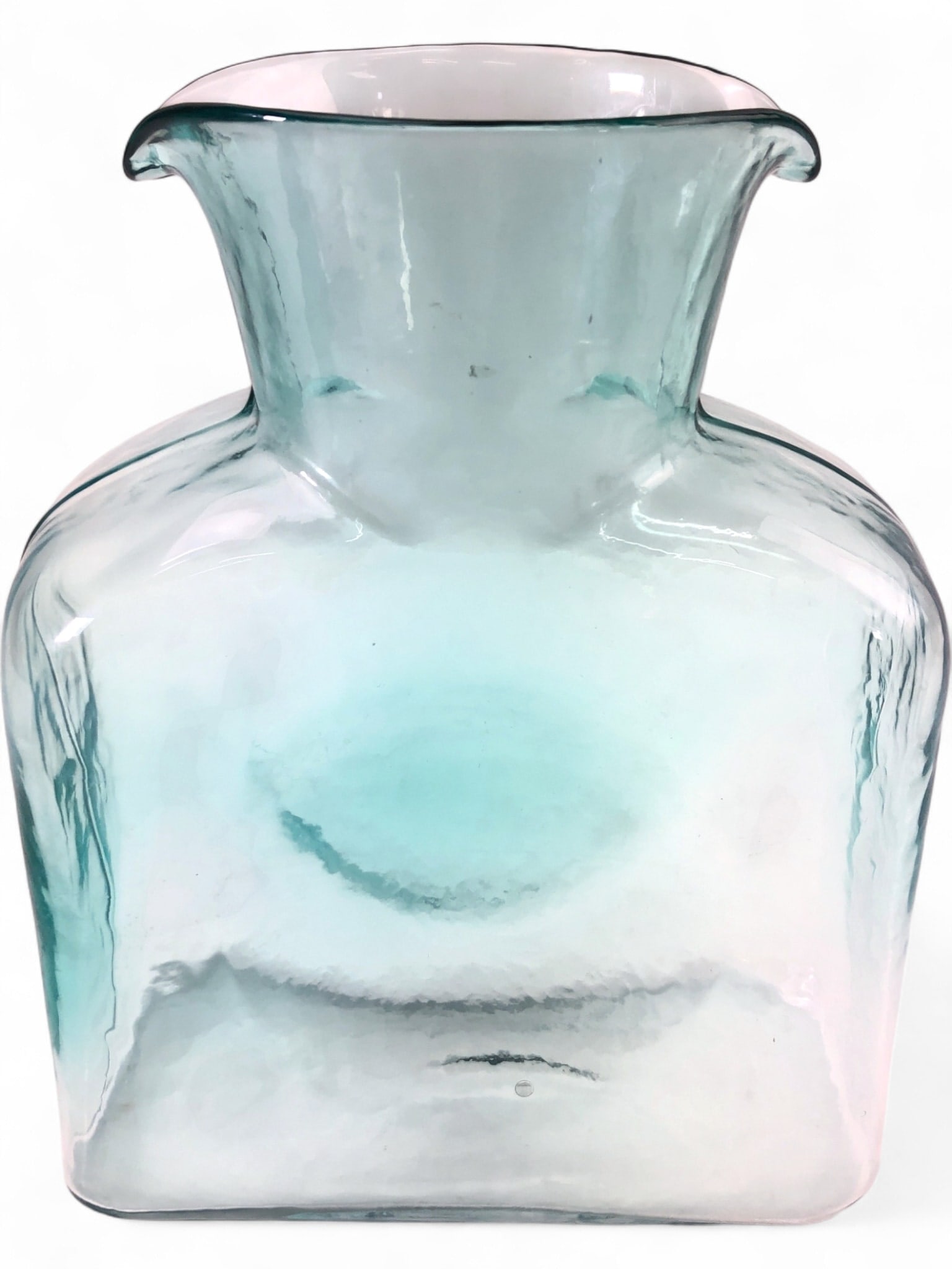 VTG Blenko Antique Green Double Spouted Pitcher: VTG Blenko Double Spouted Water Pitcher, crafted from hand-blown antique green glass. Features a distinctive rectangular body with a flared neck and two pouring spouts. Measures 8 1/8" H. Characterist
