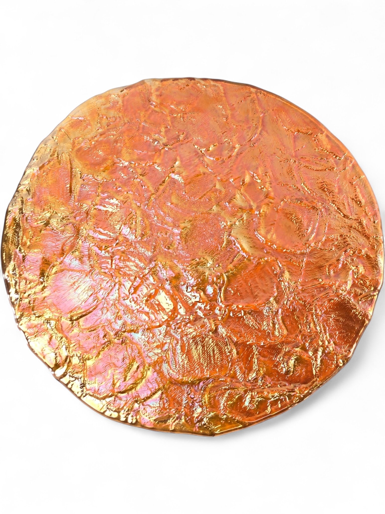 JSG Ocean Iridescent Art Glass Serving Platter: Handmade iridescent art glass serving platter by JSG Ocean. This circular platter features a richly textured surface with a vibrant iridescent finish, displaying shifting hues of orange, gold, and pin