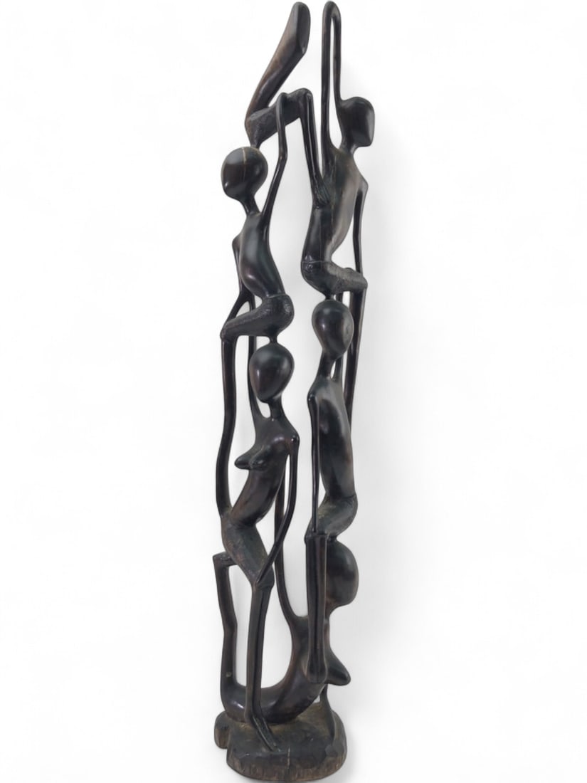 African Style Carved Wood Sculpture: African style carved wood sculpture depicting multiple stylized human figures in a stacked formation, often referred to as a 'Tree of Life' or 'Ujamaa' carving. Crafted from dark, dense wood. Unsigned